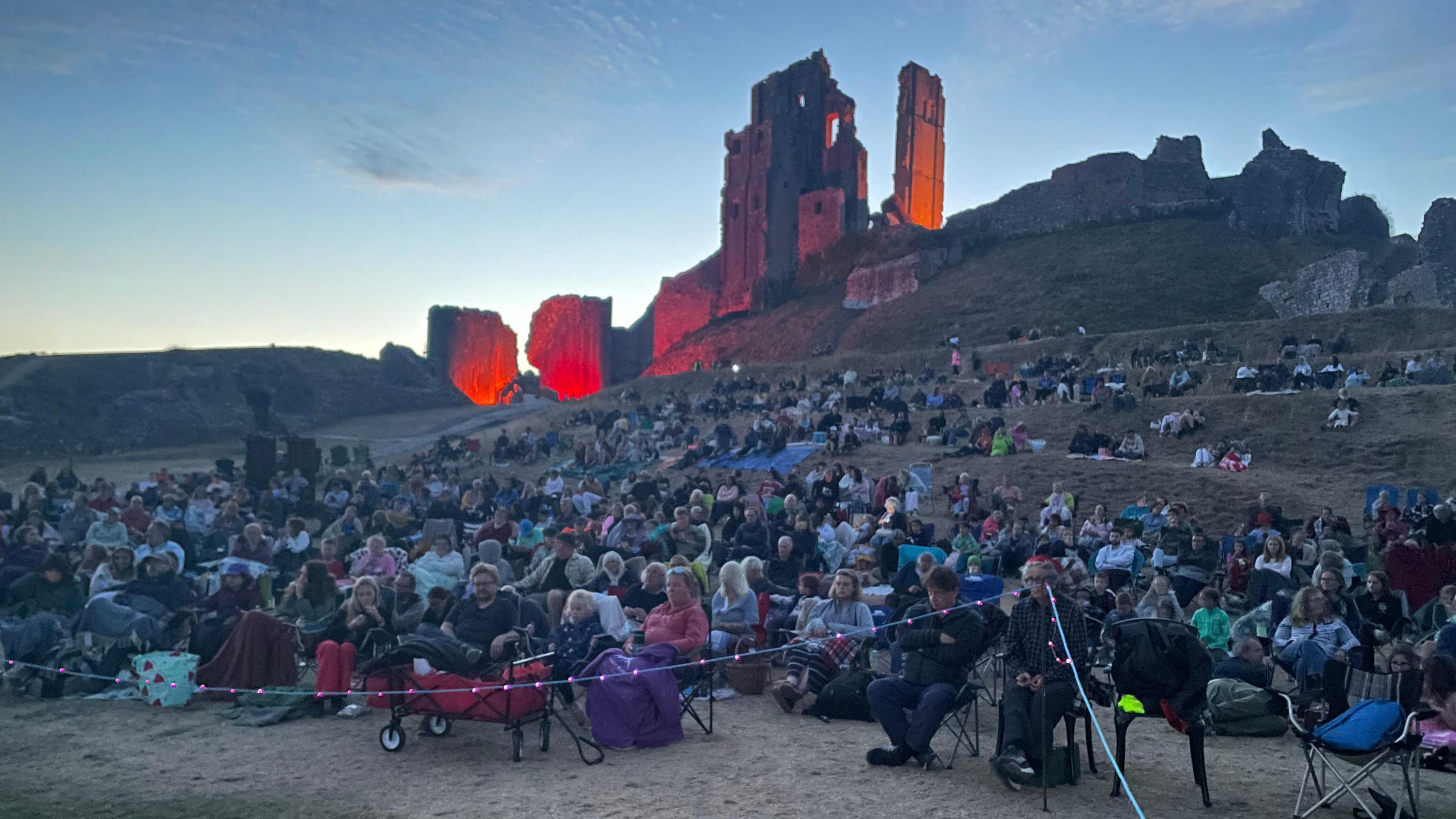 Hundreds of people sat out in front of the ruins of Corfe Castle at dusk ready to watch Paddington in Peru.