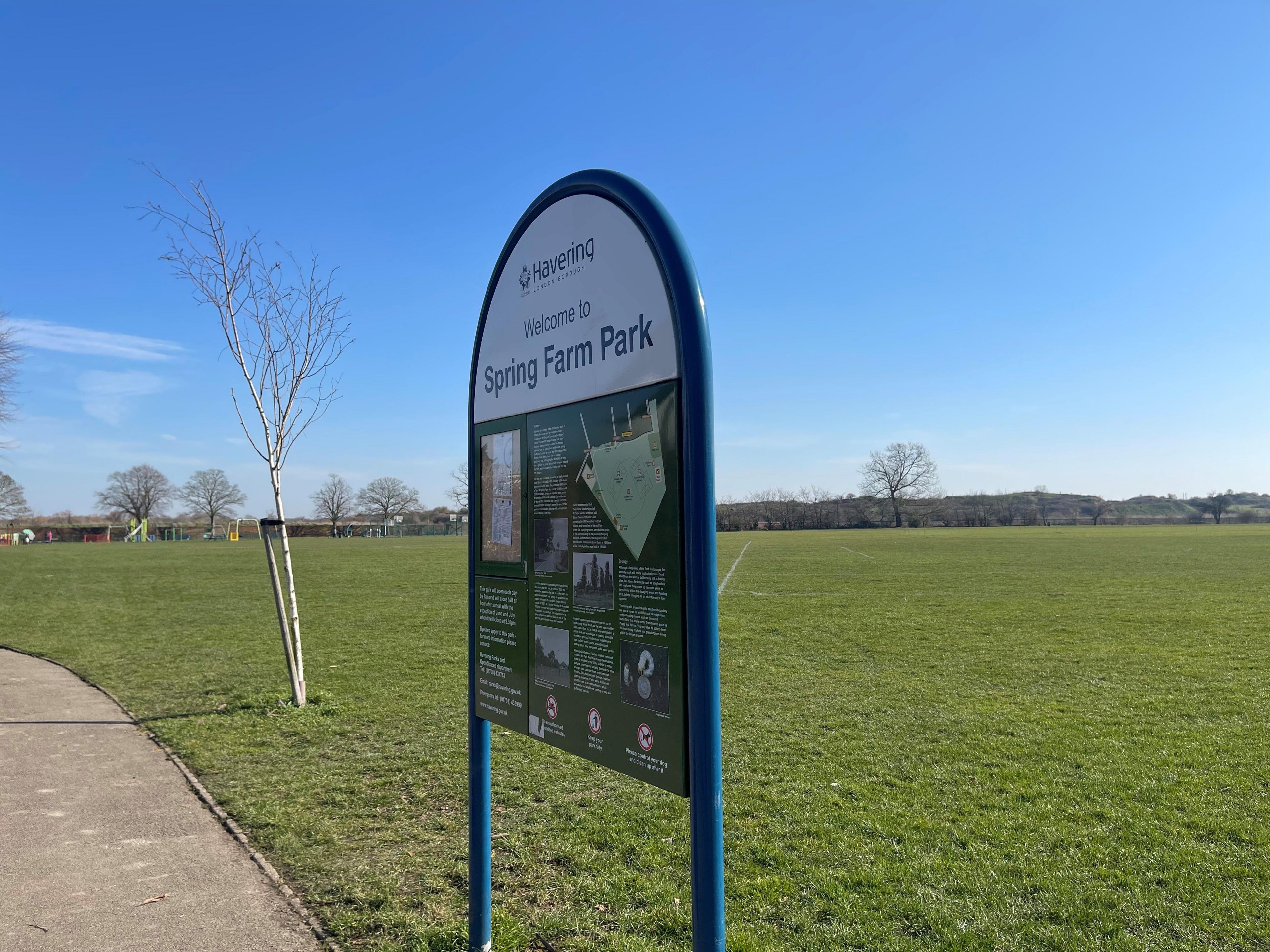 A public park and sign with landfill hill in the background