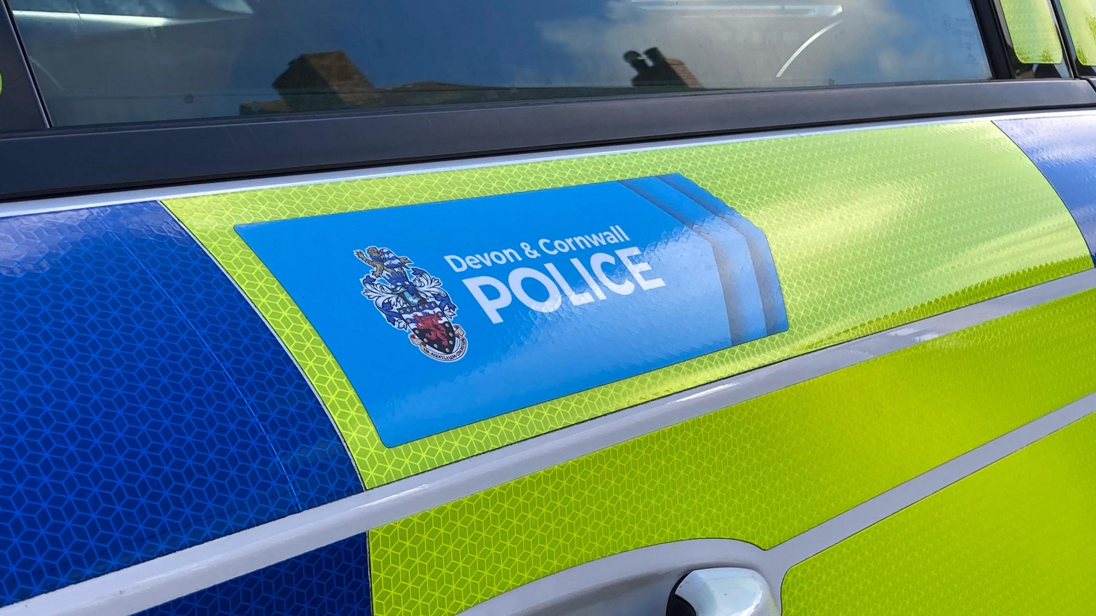 A Devon and Cornwall Police car with a blue and fluorescent yellow marking and force logo.