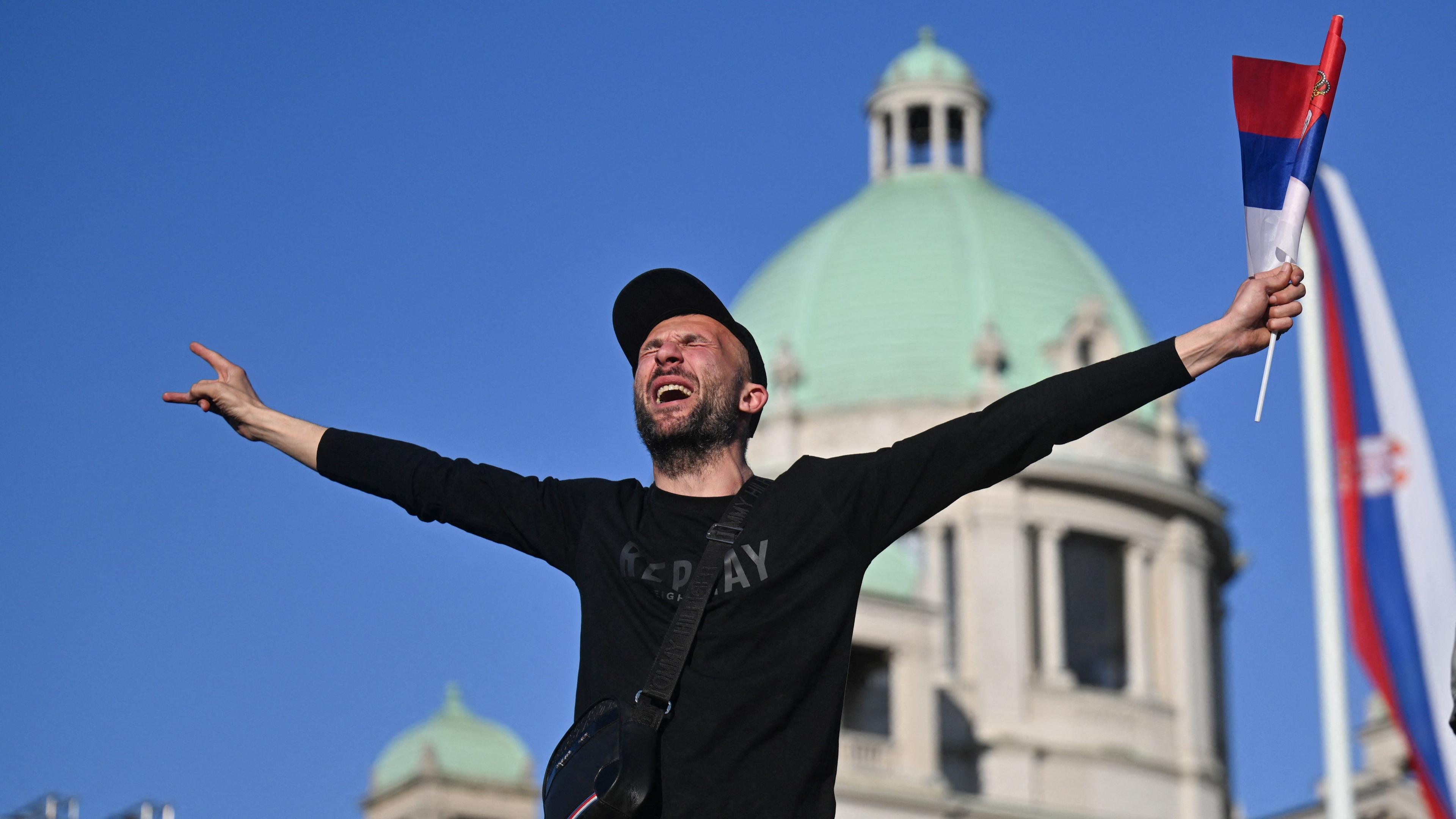 A supporter of Serbia's President waves a national flag during a pro-government rally in Belgrade