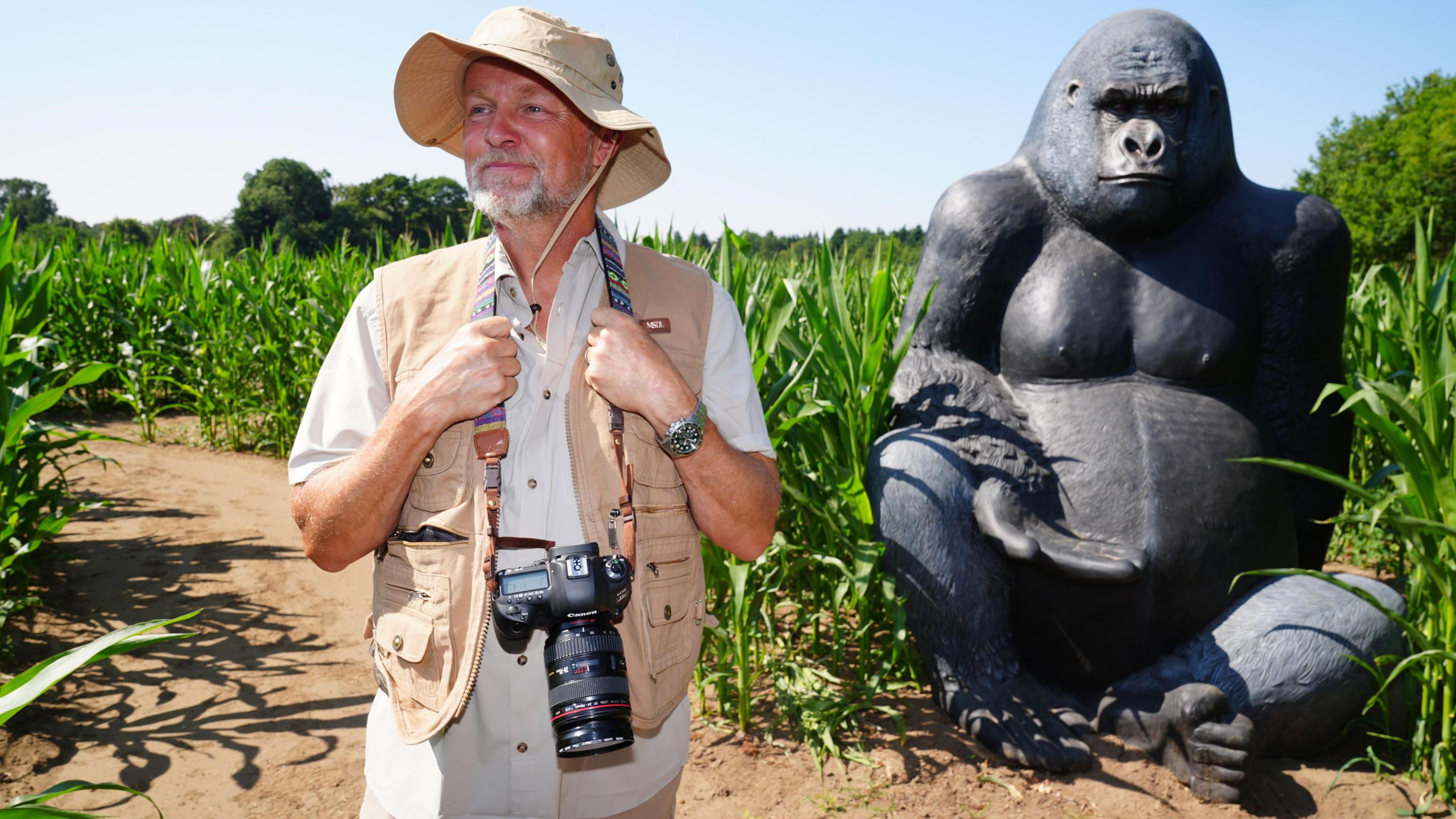 York Maze owner Tom Pearcy posing in front of a statue of a giant gorilla in the maze