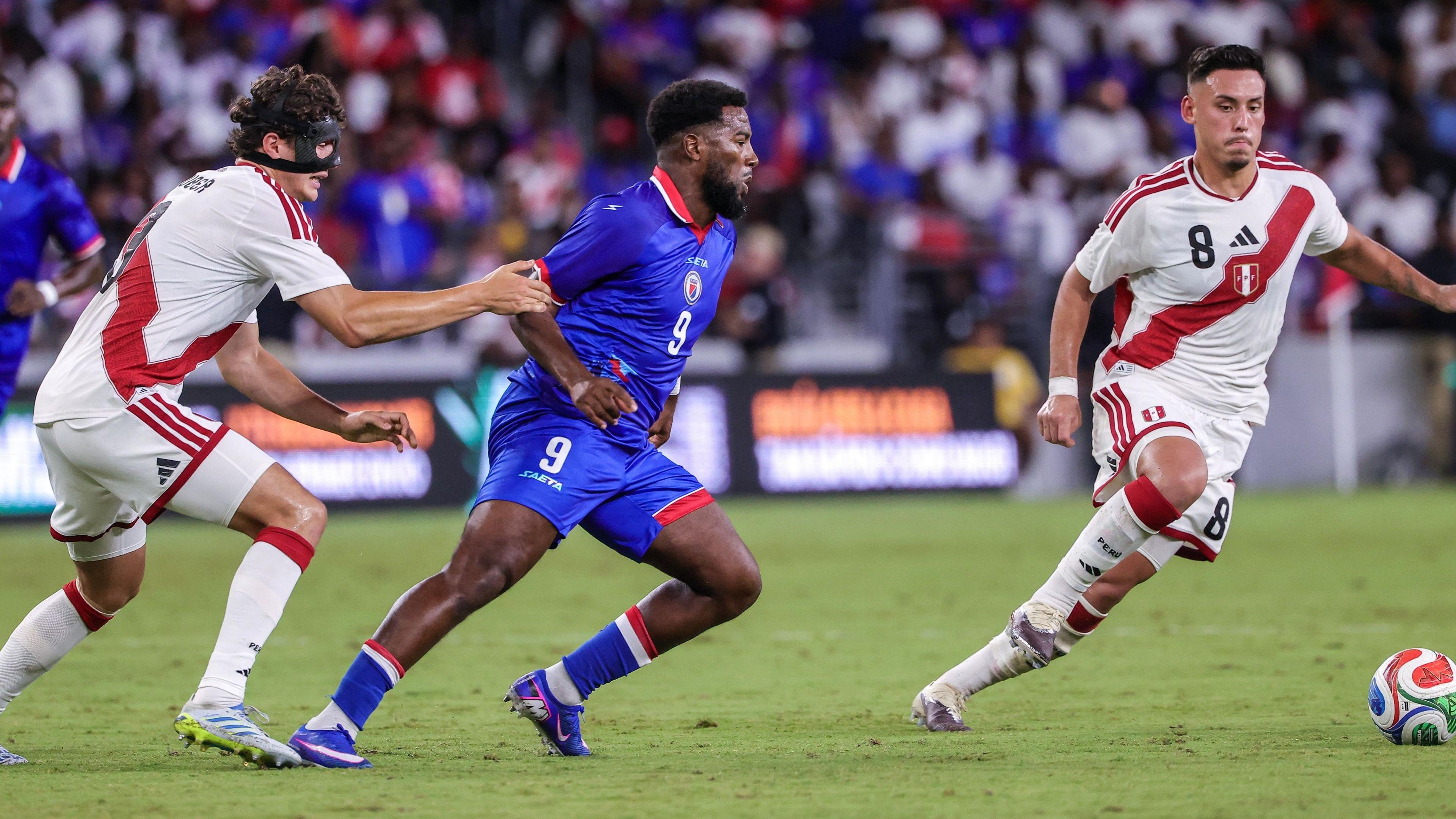Haiti's Duckens Nazon (centre) in action against Peru