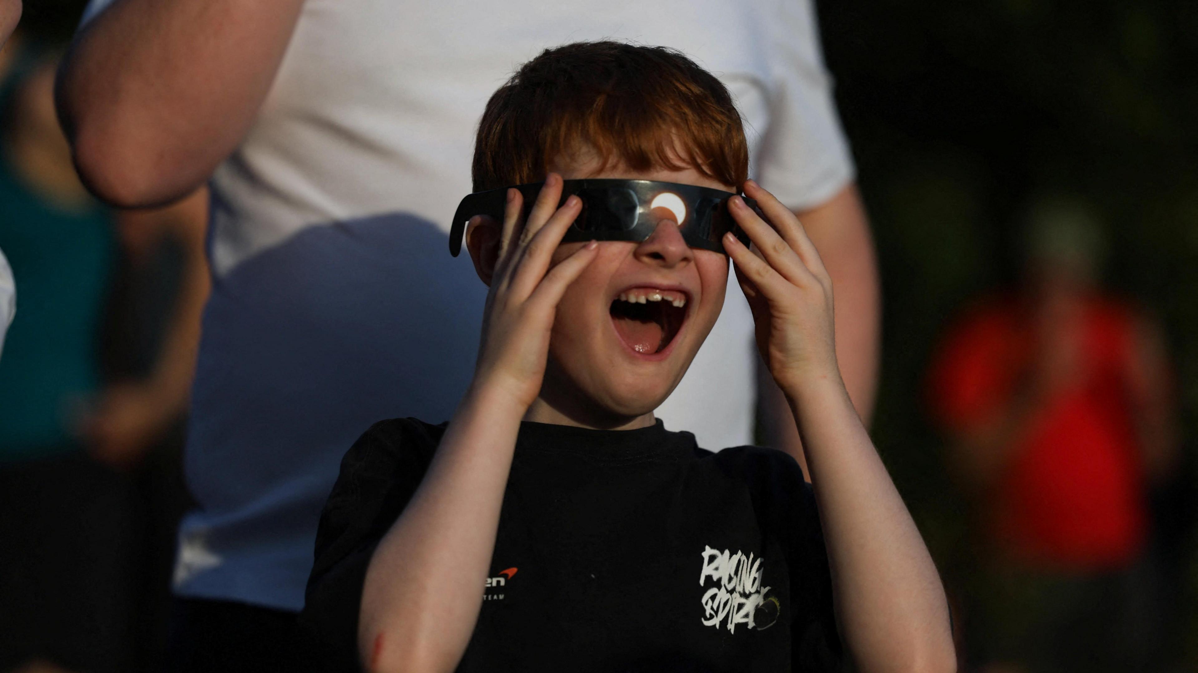 A boy wears special protective glasses to observe a partial solar eclipse at Jodrell Bank observatory near Macclesfield.
