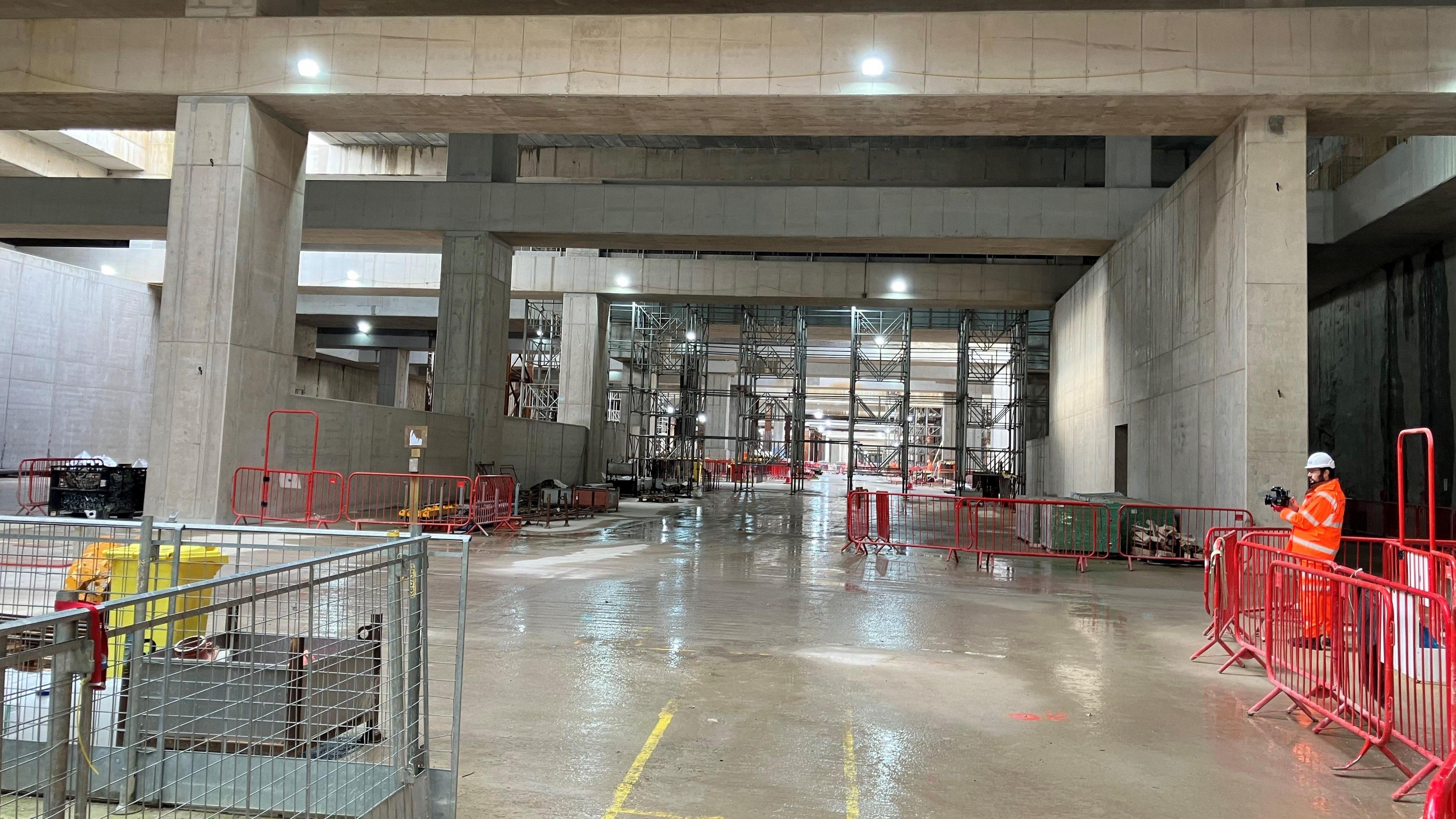 A construction site with a large, open area with concrete pillars and beams.