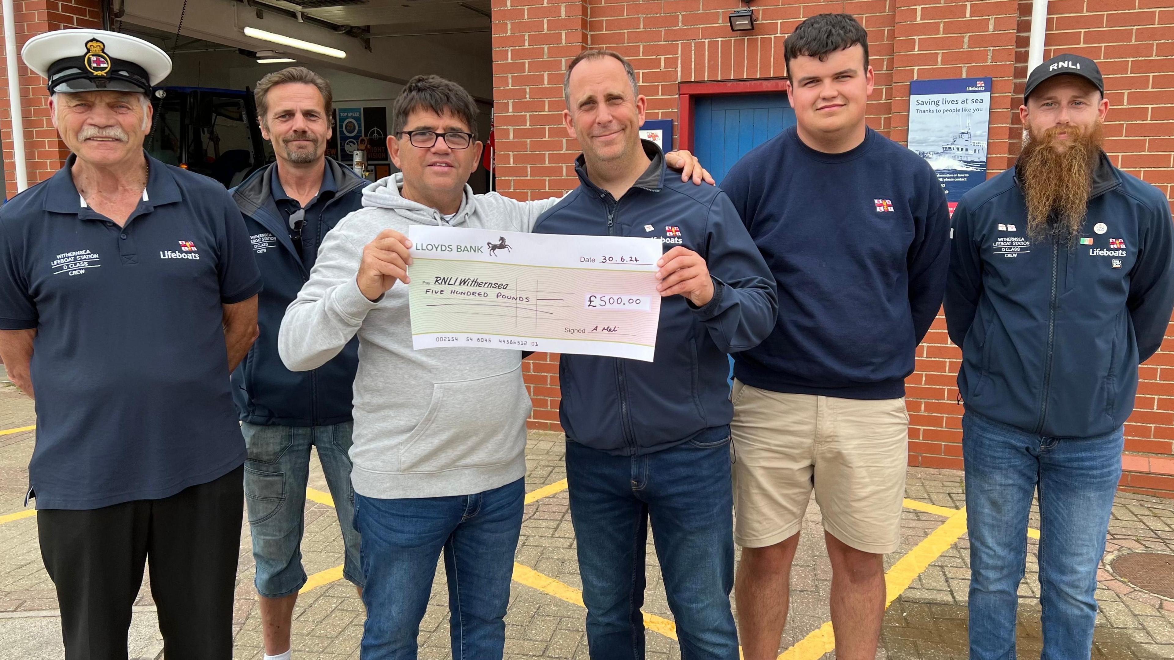 RNLI Withernsea crew receive a cheque for £500 from Antony Meli