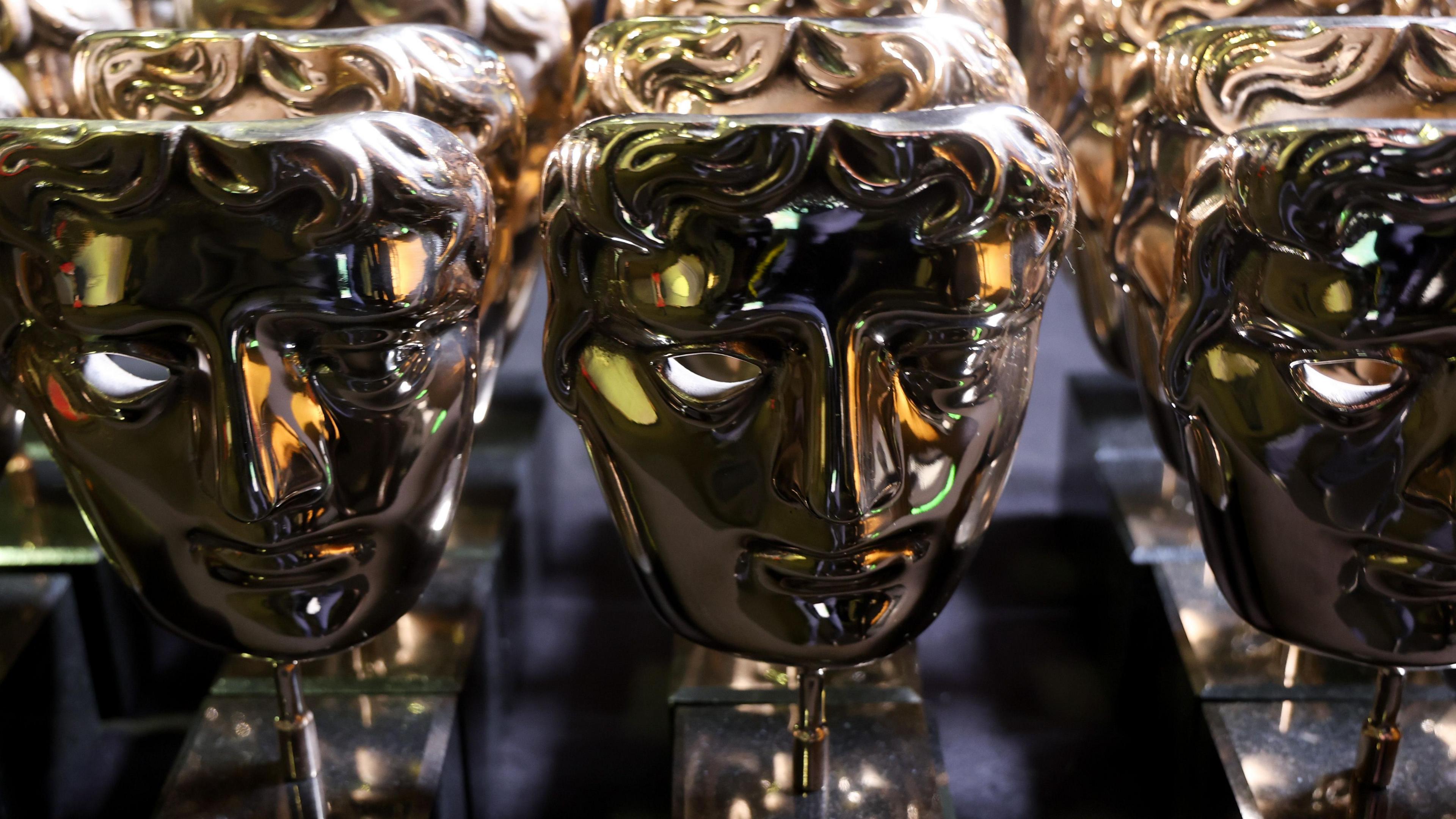 A collection of Bafta Award trophies on display