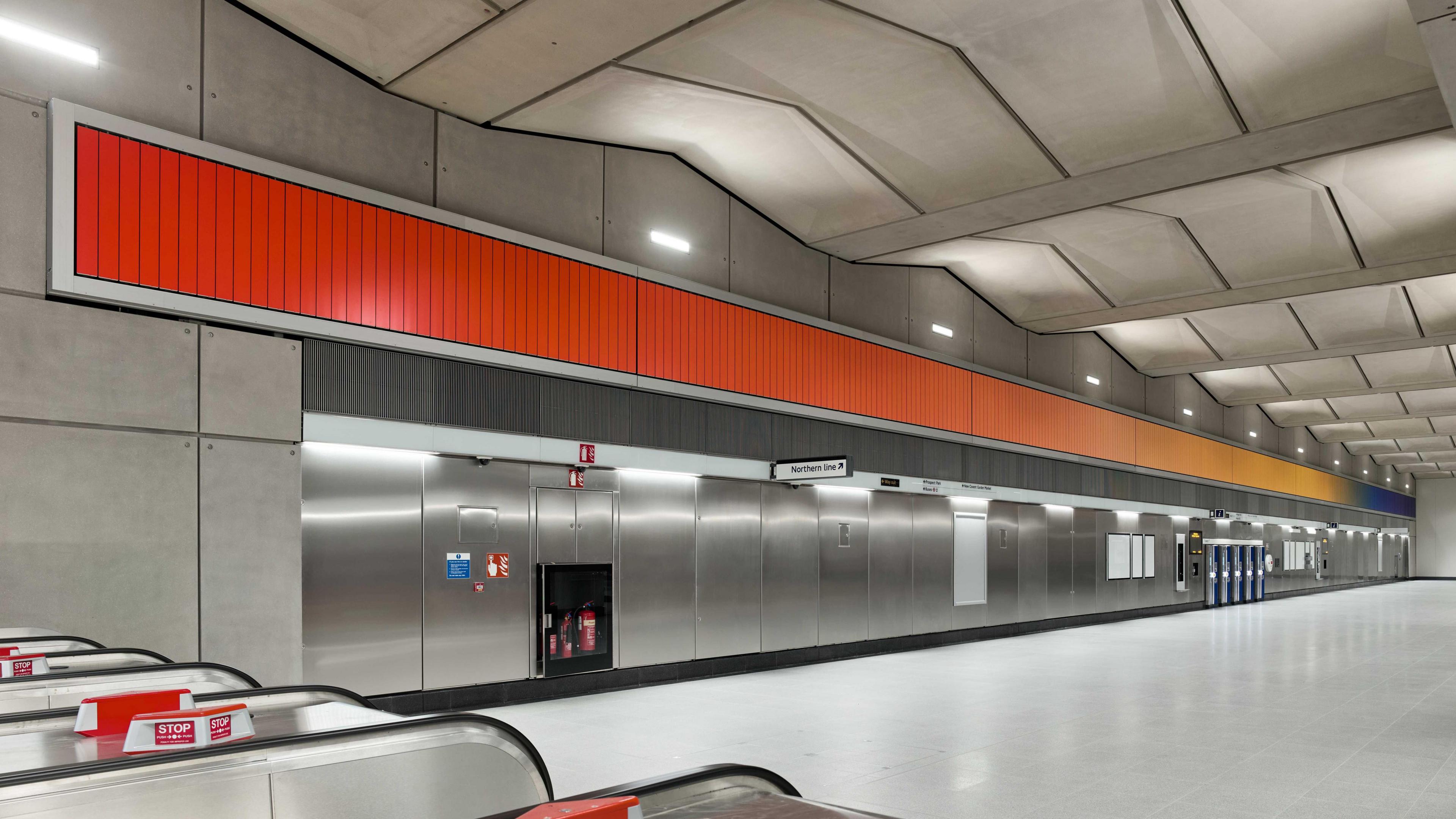 An artwork sited near the ceiling runs the length of a Tube station more than 320 feet, at one end it is deep orange and it turns yellow and then blue further down. 