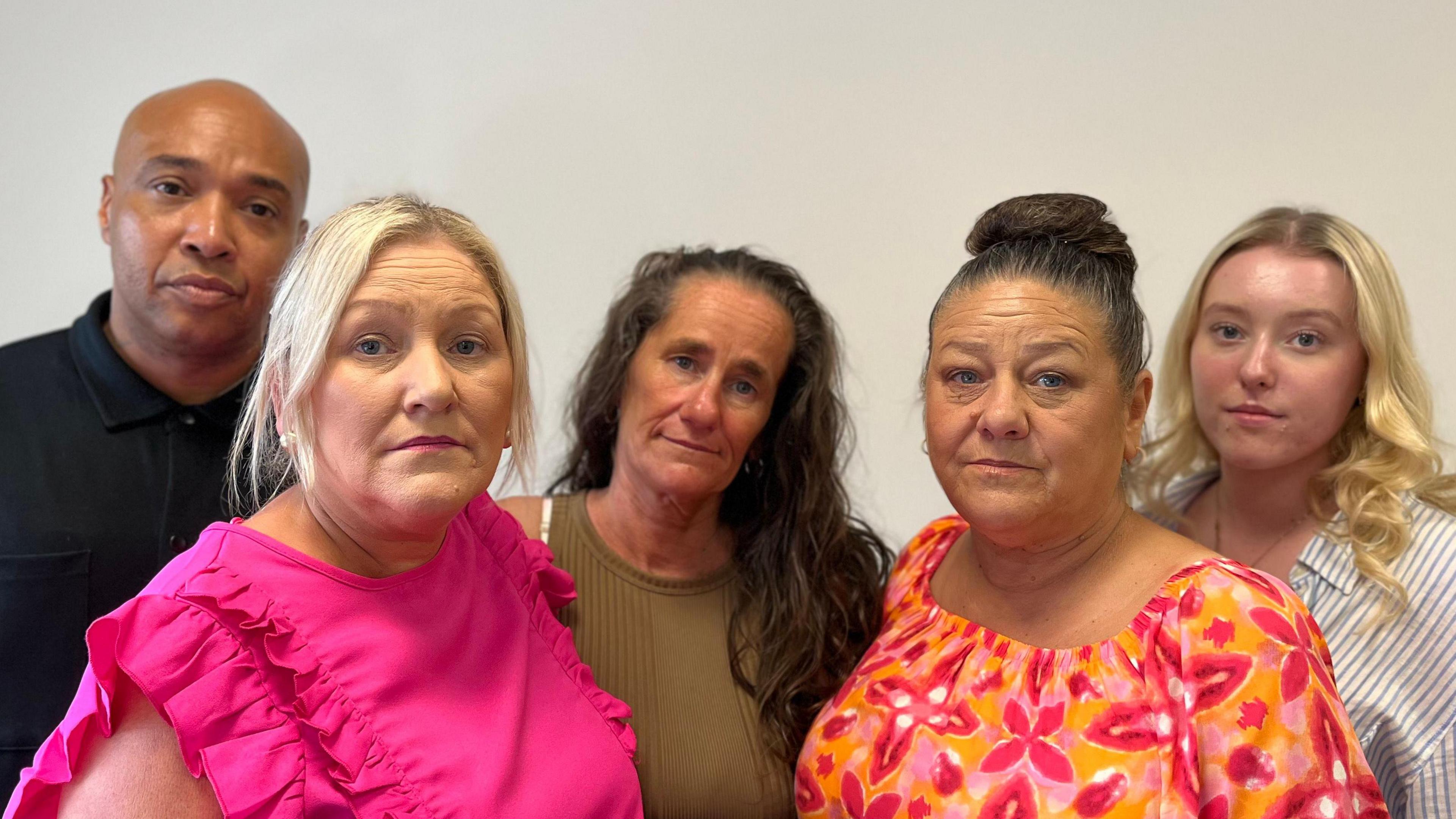 Kaine Fletcher's family, from left to right, Kaine's father, wearing a black T-shirt, his aunt wearing a pink T-shirt, his mum, wearing a khaki green dress, another aunt, wearing an orange and pink floral dress and his cousin wearing a striped, blue and white shirt.