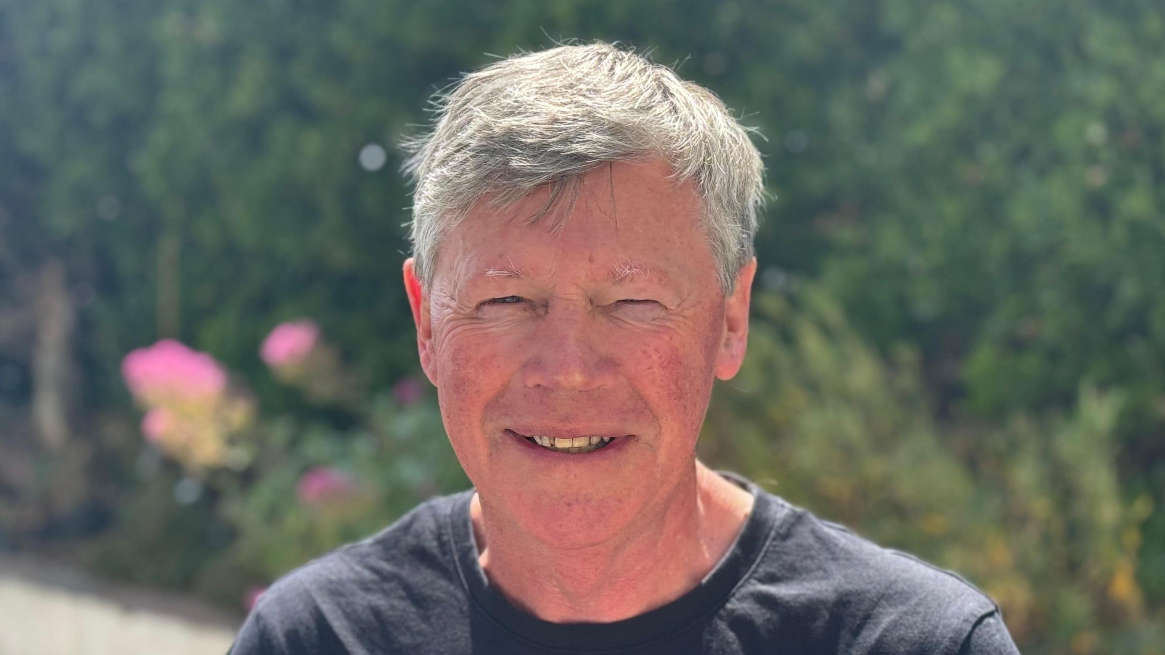A head and shoulders shot of John Gaynor. He is smiling while looking directly into the camera.