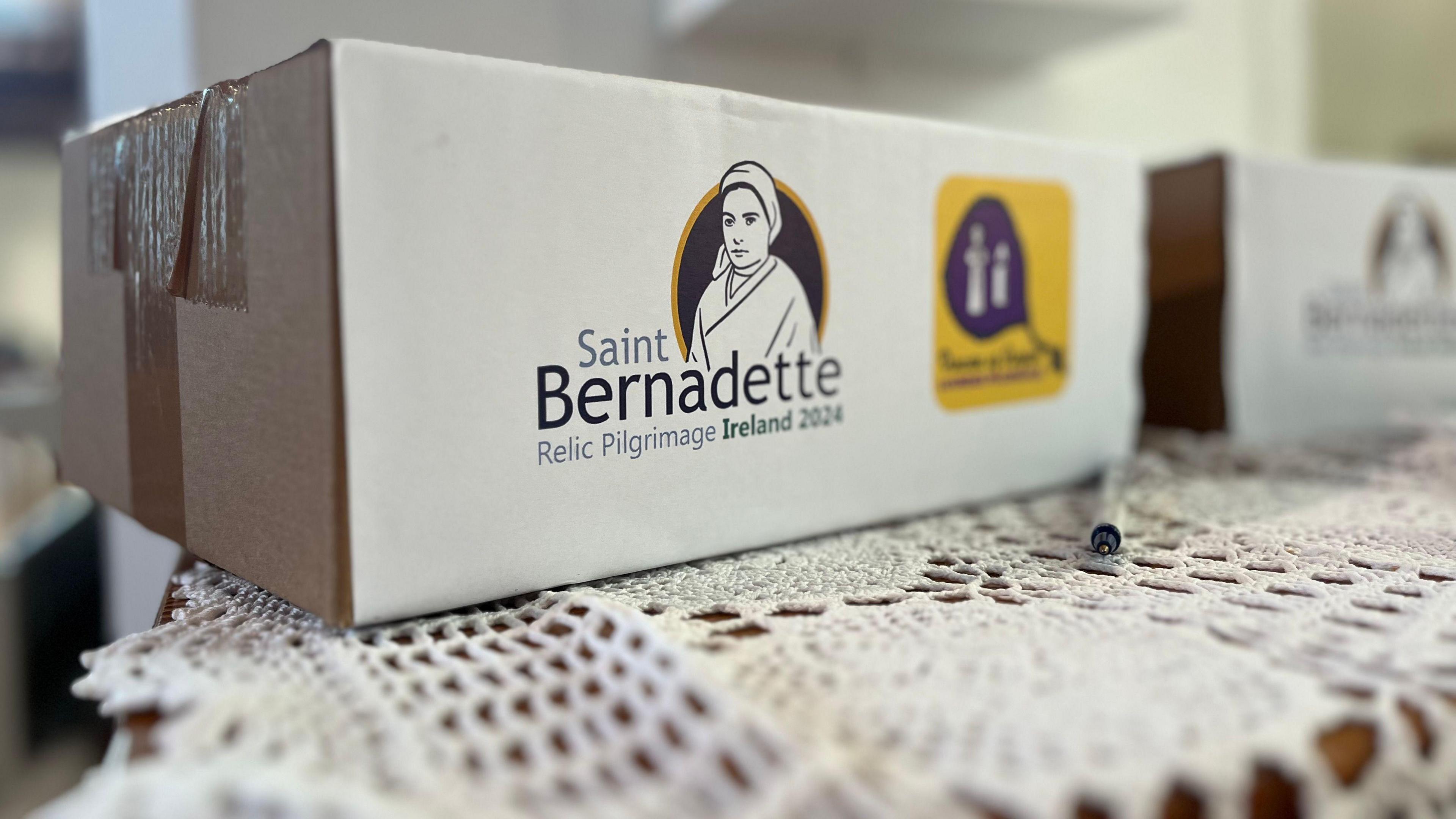 A collection box that says Saint Bernadette Relic Pilgrimage Ireland 2024