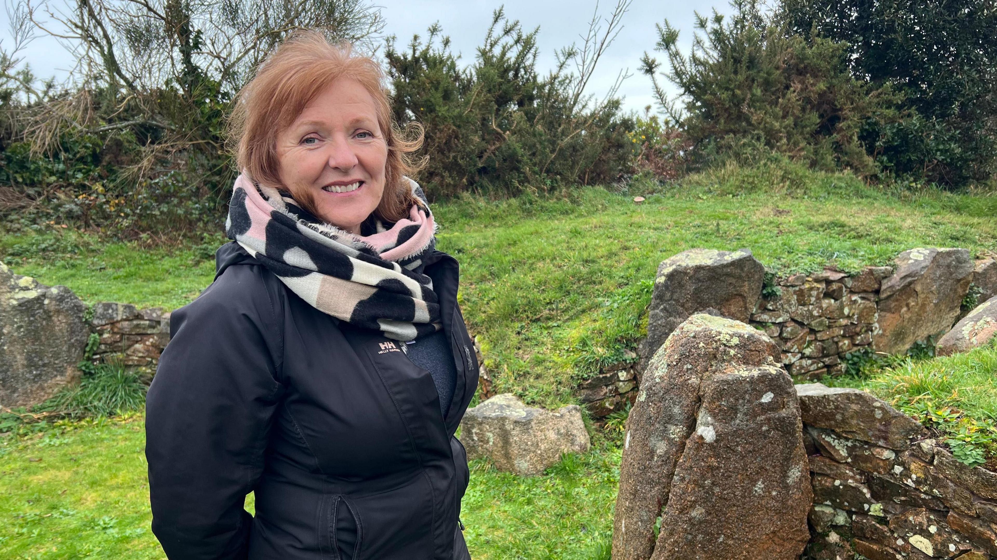 A lady stands in the middle of a dolmen - circular standing stones