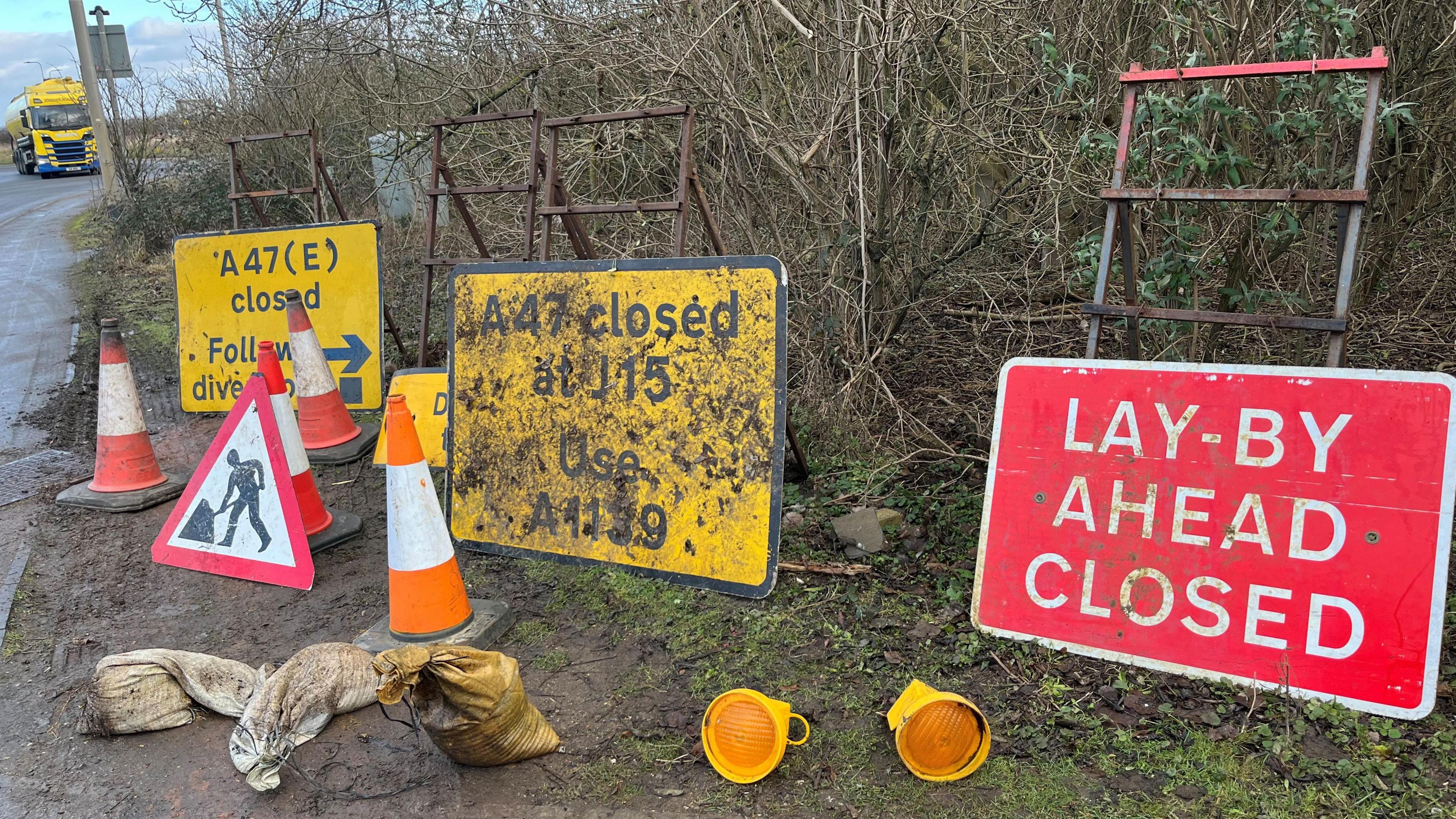 A selection of items found by Mr Fishpool in hedges and verges around Peterborough including traffic management signs, orange and white bollards, sandbags and safety lamps which fit on bollards and flash an orange light.