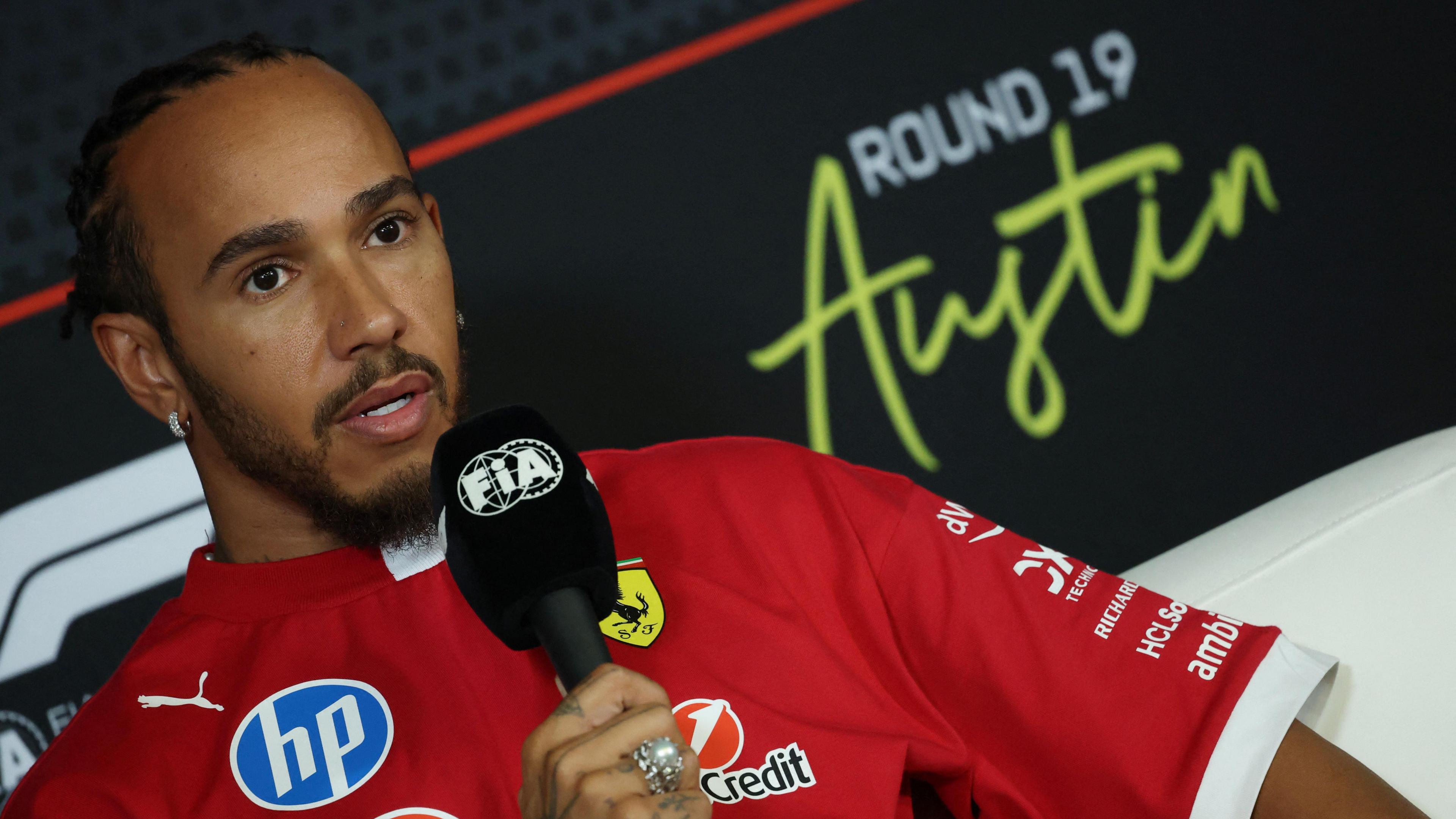 Lewis Hamilton holds an FIA-branded microphone in the United States Grand Prix news conference on Thursday
