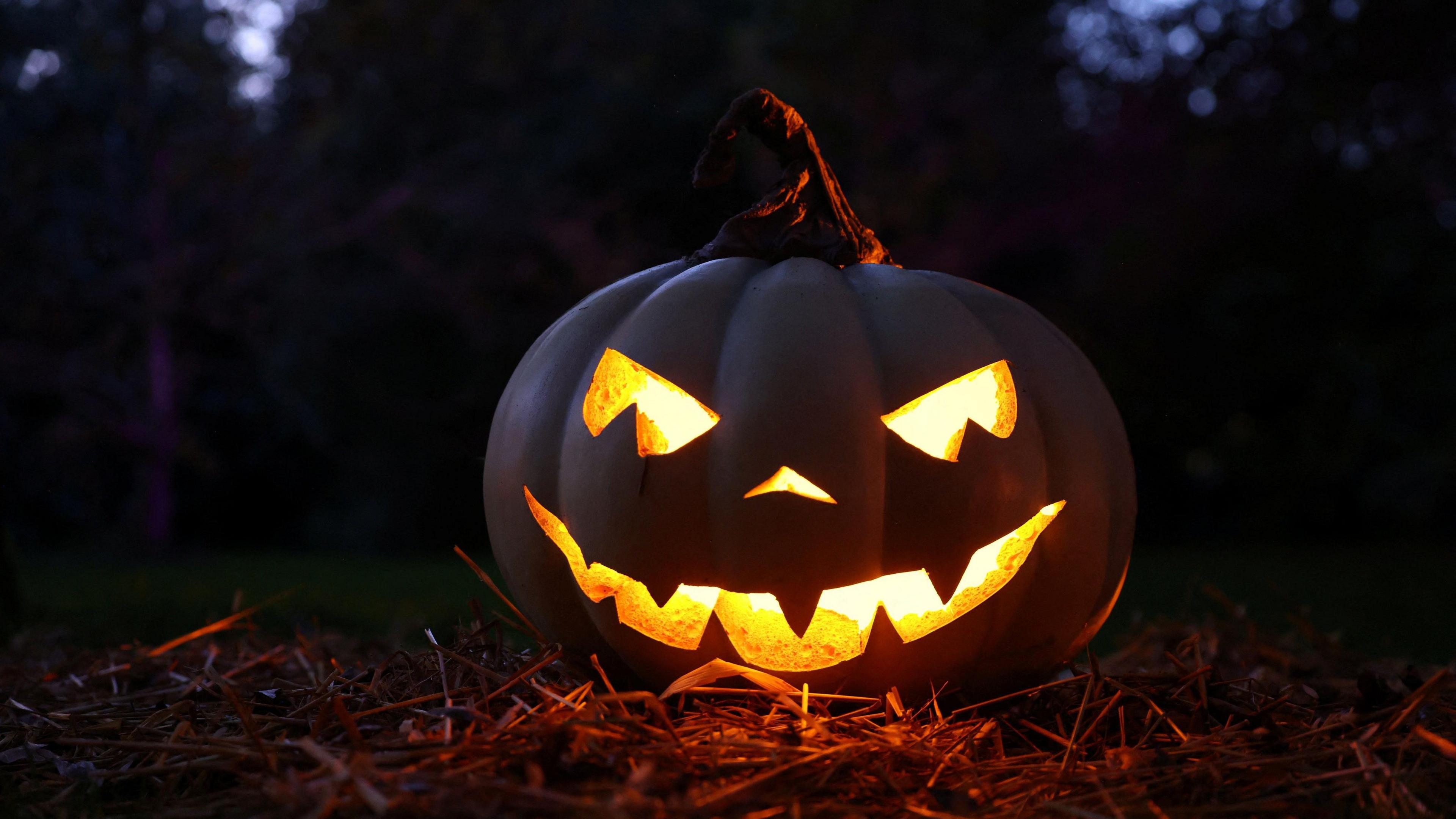 Carved face on a pumpkin with a light inside glowing menacingly