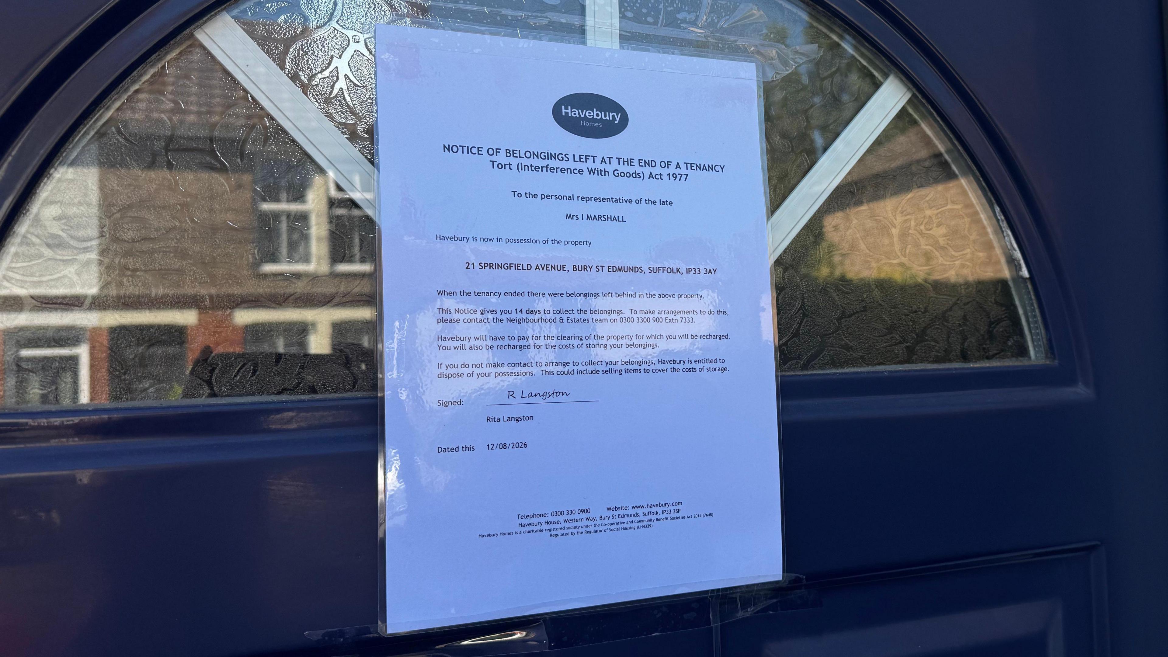 A Havebury Homes notice placed on a blue front door.