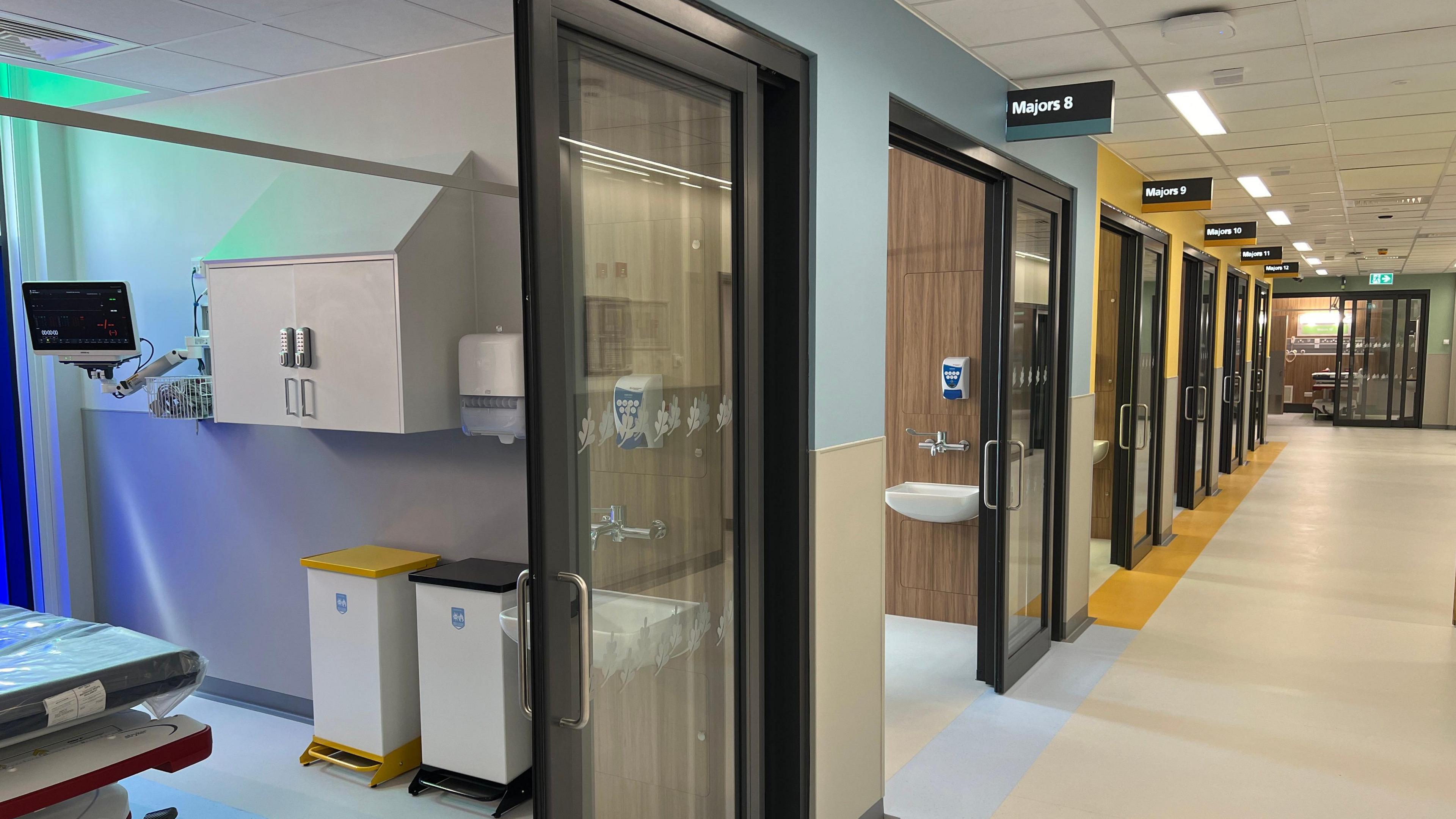 A corridor with patient treatment cubicles next to them