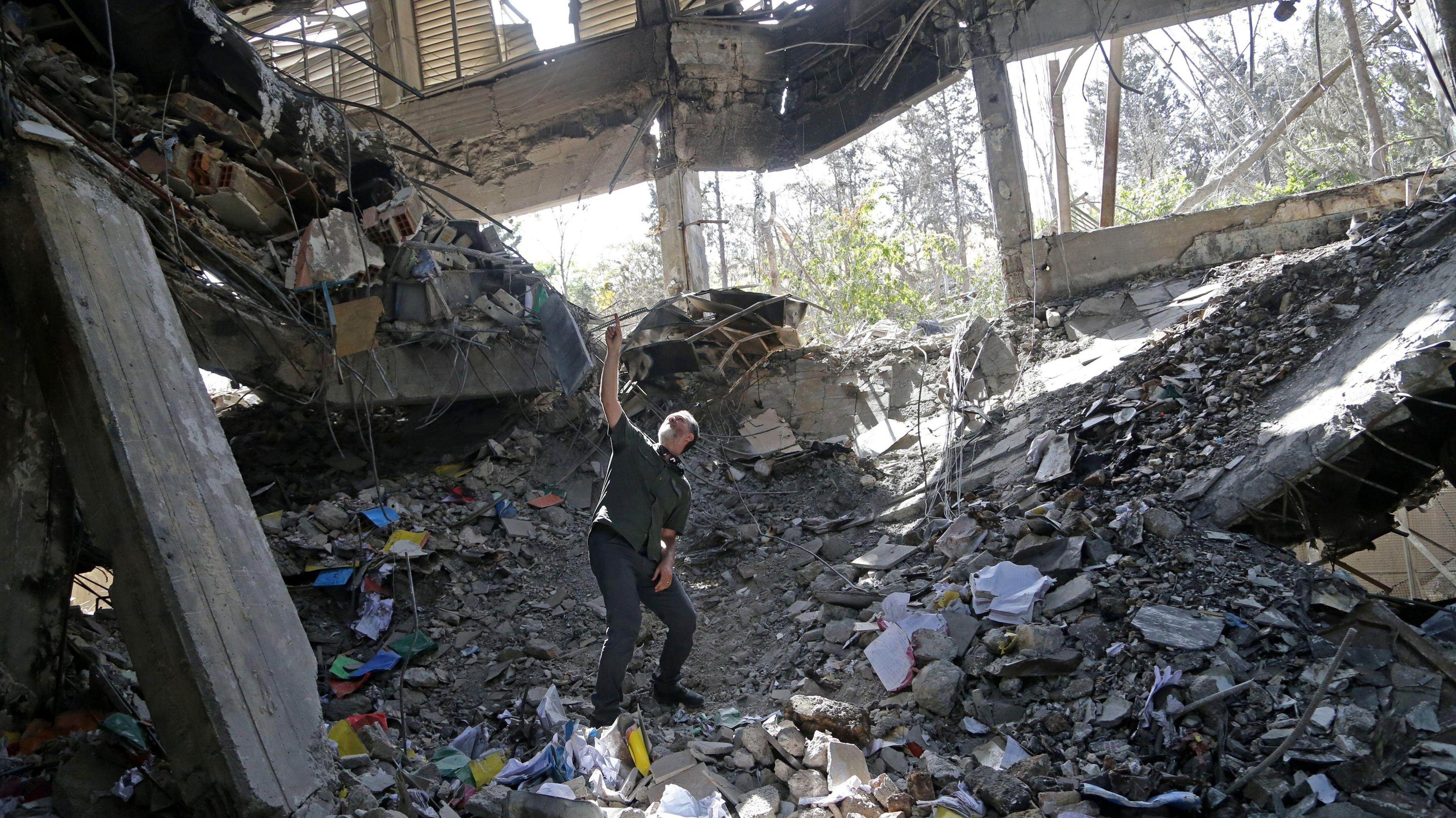 A man stands amongst the ruins of a prison building in Iran
