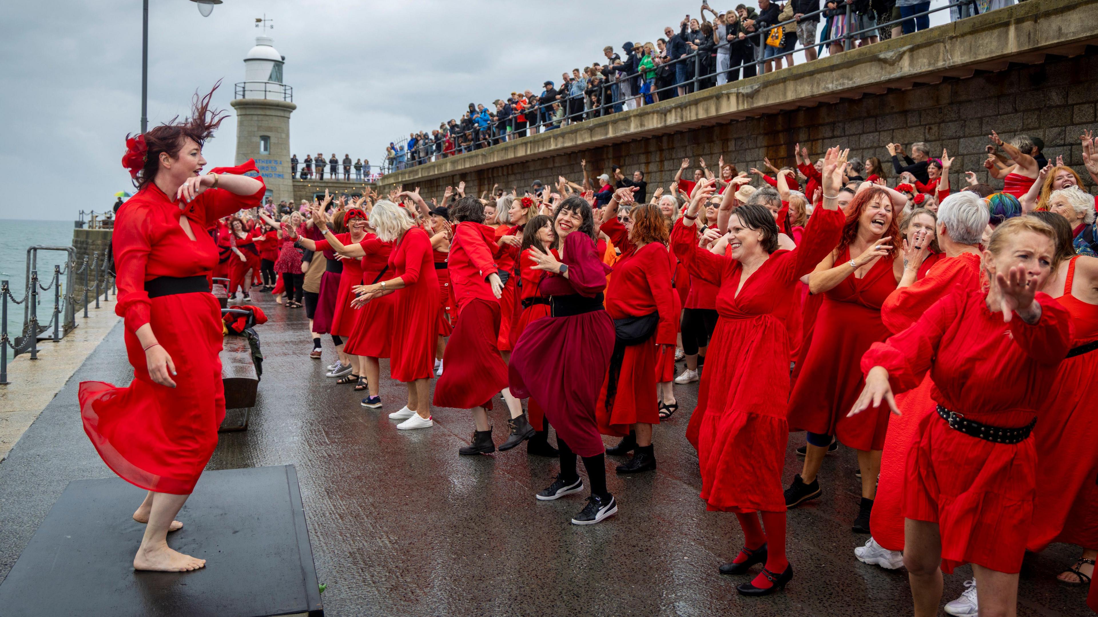 Hundreds of Kate Bush fans came together today wearing red floaty dresses on Folkestone's Harbour Arm to dance to her most iconic song, Wuthering Heights on the 20th of July 2025 in Folkestone, United Kingdom.