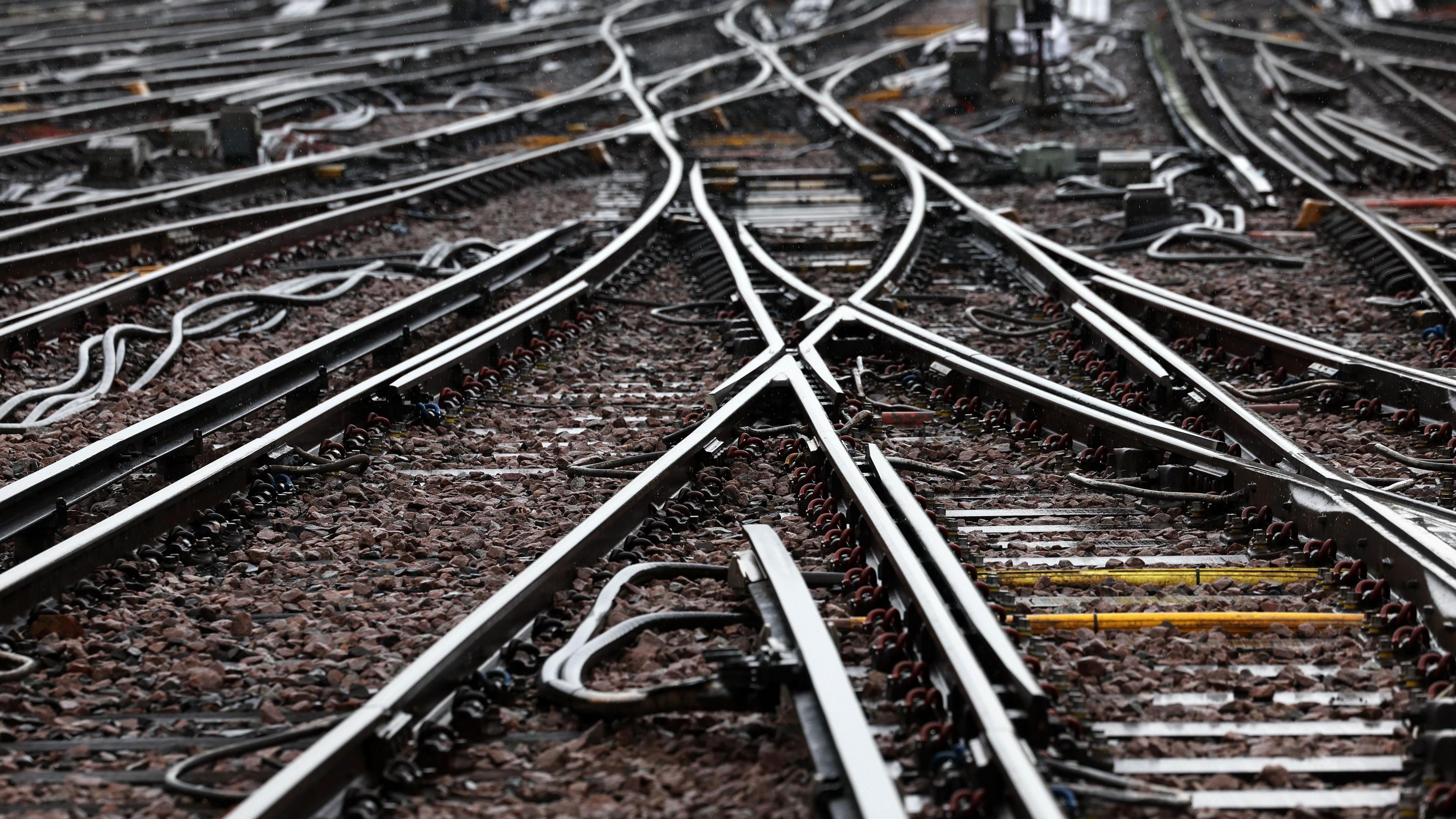 Criss-crossing rail tracks with darker ballast behind it.