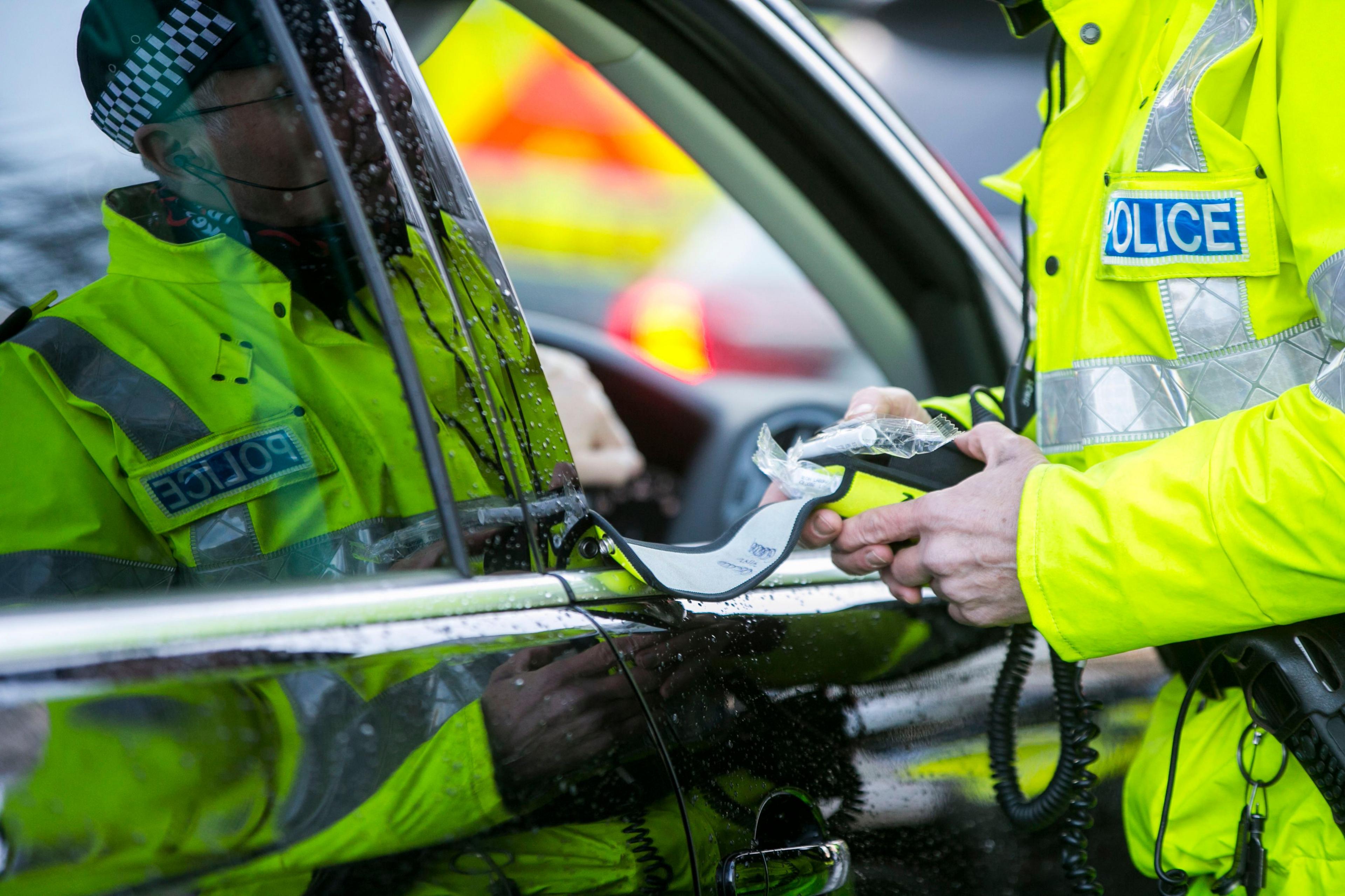 Stock image of a police officer with a breathalyser