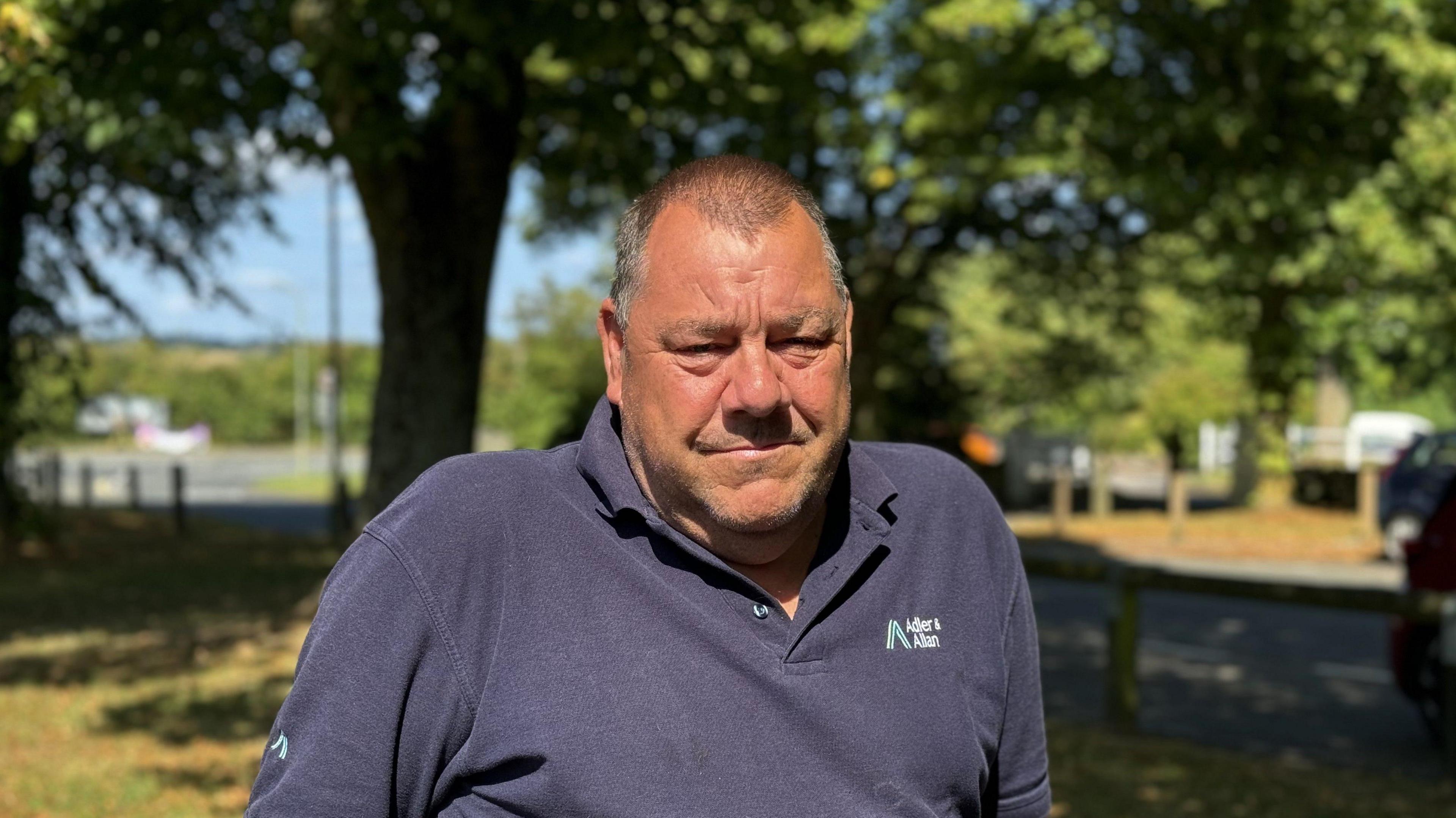 A man who is a local resident is standing in his village of Minster Lovell. 