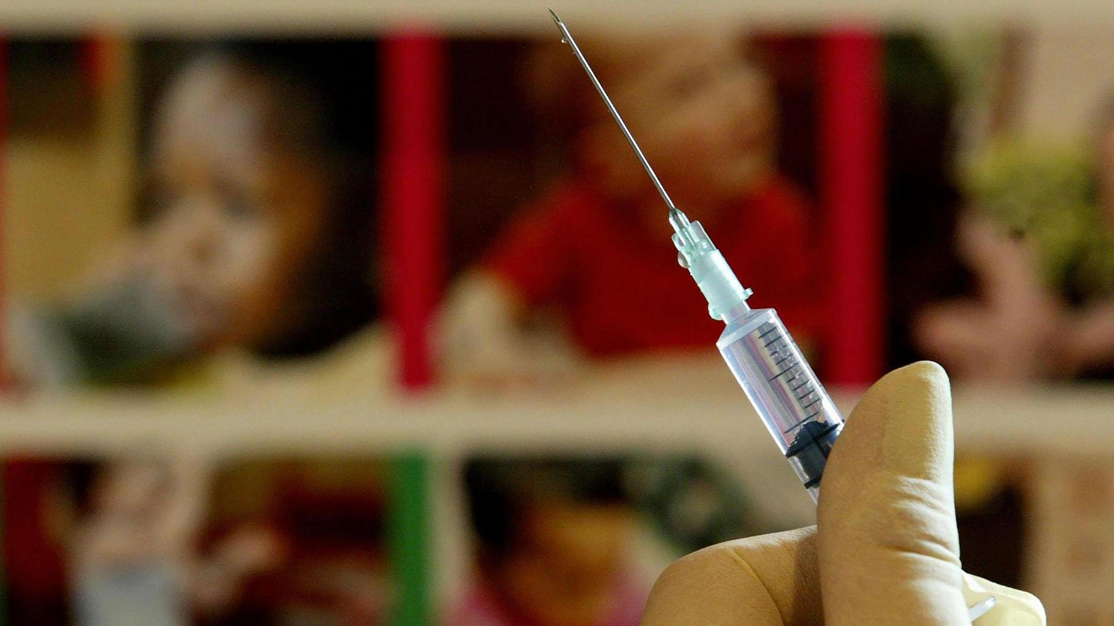 A nurse handling a jab needle