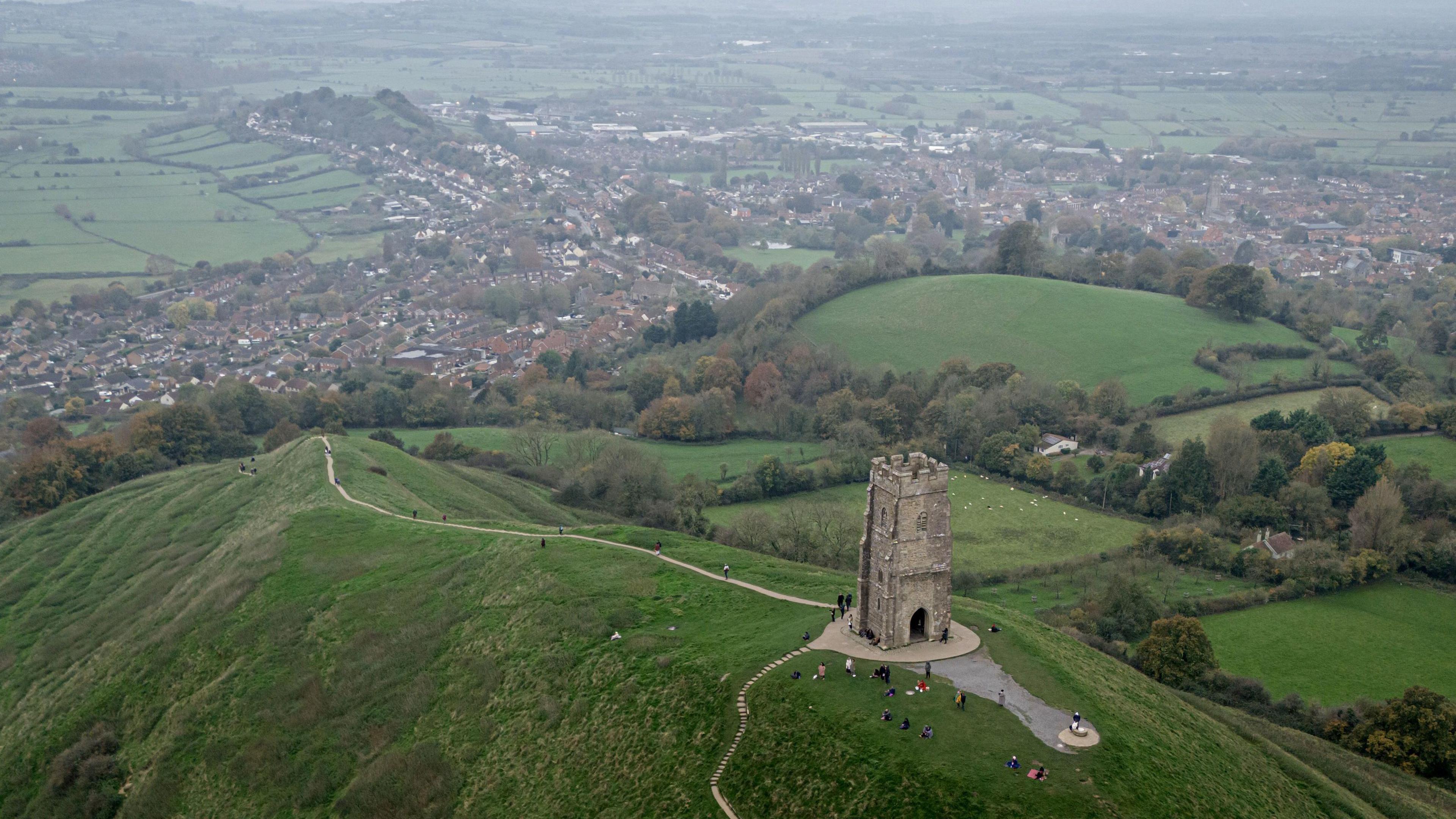 People mill around St Michael's Tower on top of Glastonbury Tor in Somerset.