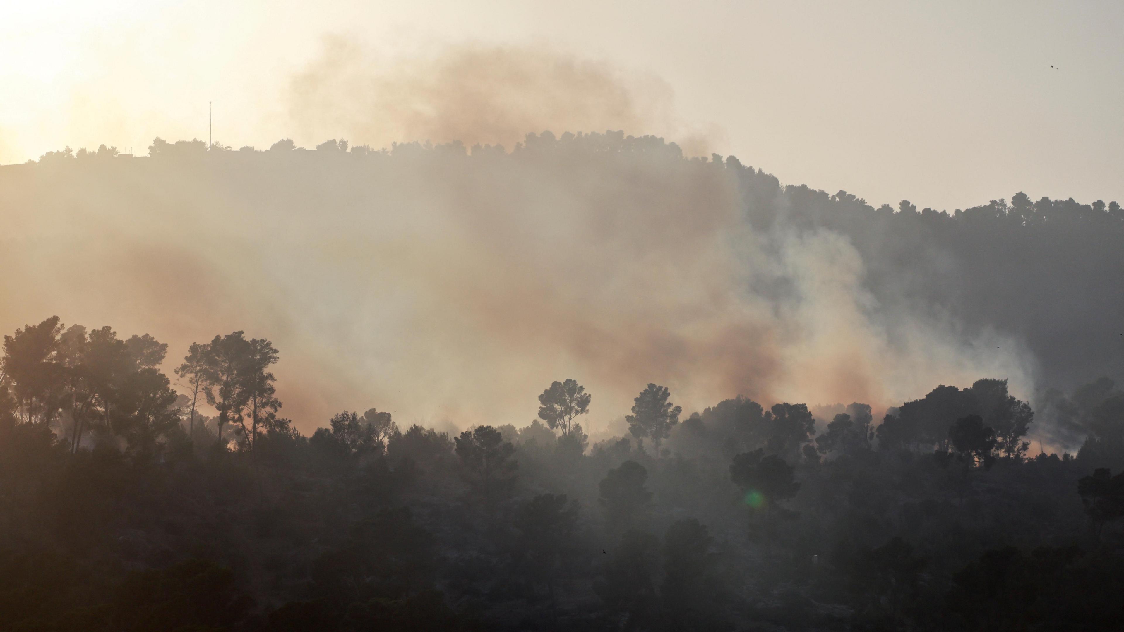 Smoke rises from the hills around Kiryat Shmona, in northern Israel, after a Hezbollah rocket attack (9 October 2024)