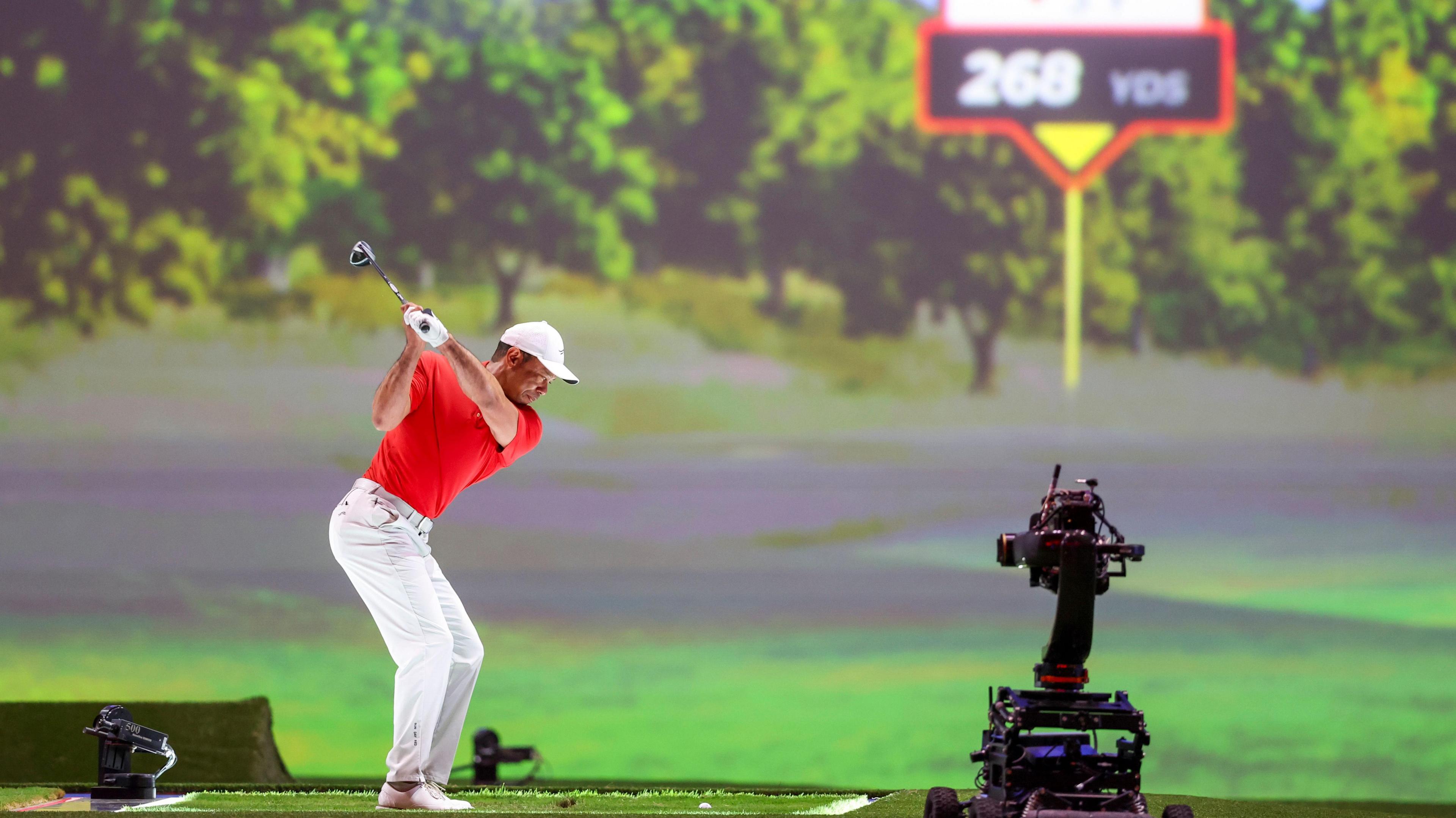 Tiger Woods hitting a shot into a big screen during the indoor TGL tournament