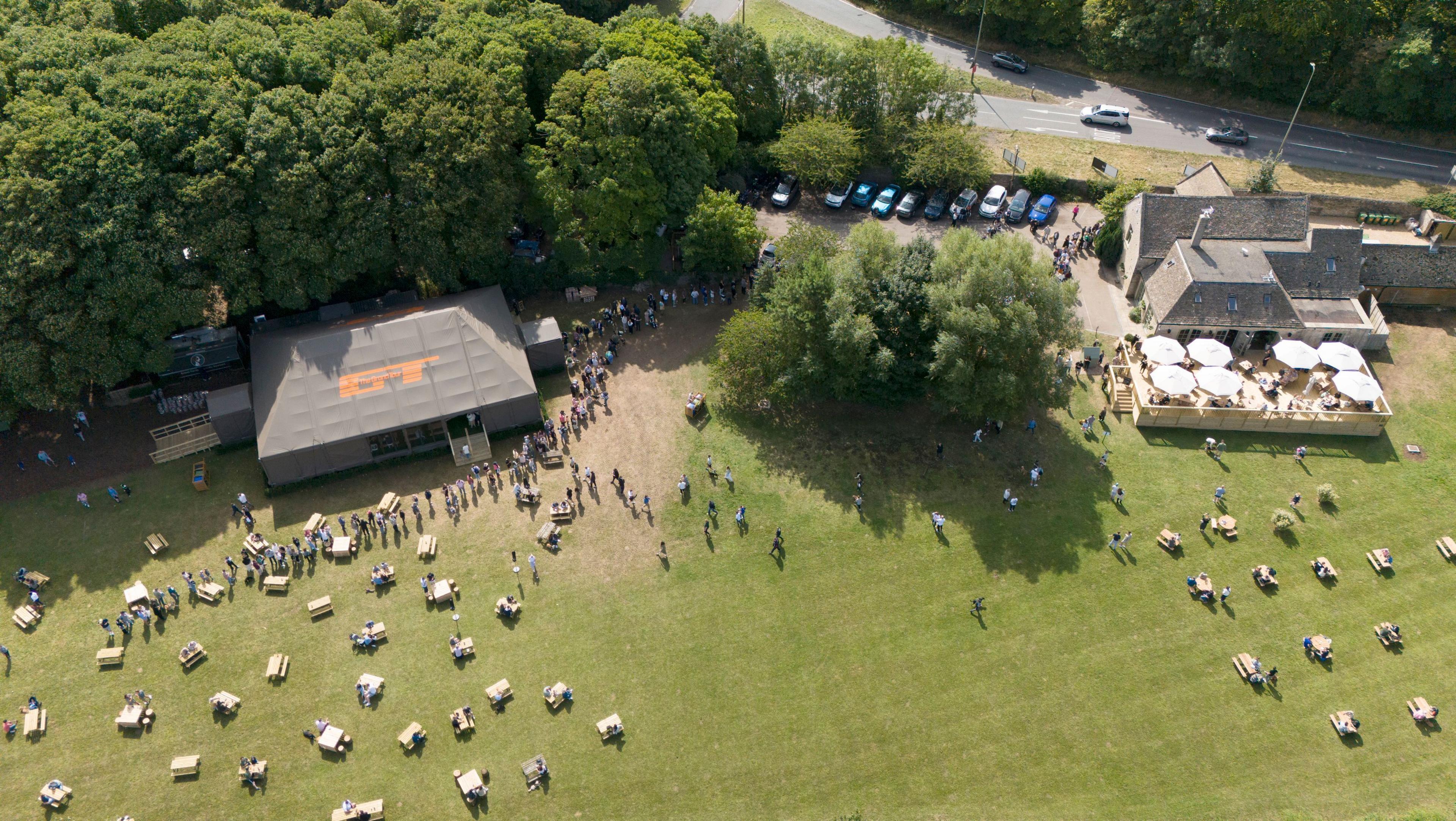 The Farmer's Dog pub and its garden seen from above, with people relaxing on outside benches. 