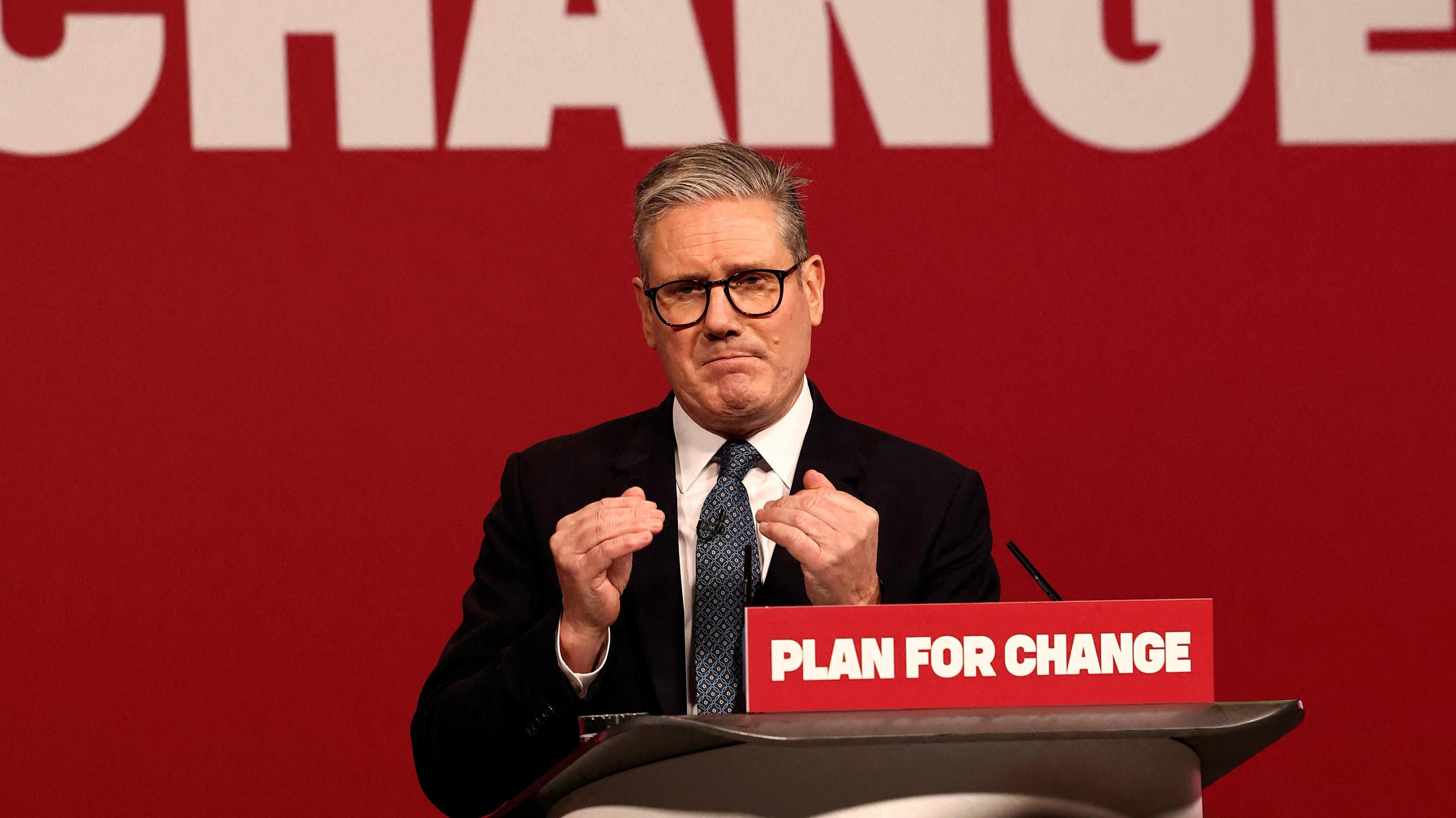 Sir Keir Starmer giving a speech on Thursday, standing behind a lectern with the motto 'Plan for change' on it. He is gesturing with his hands.