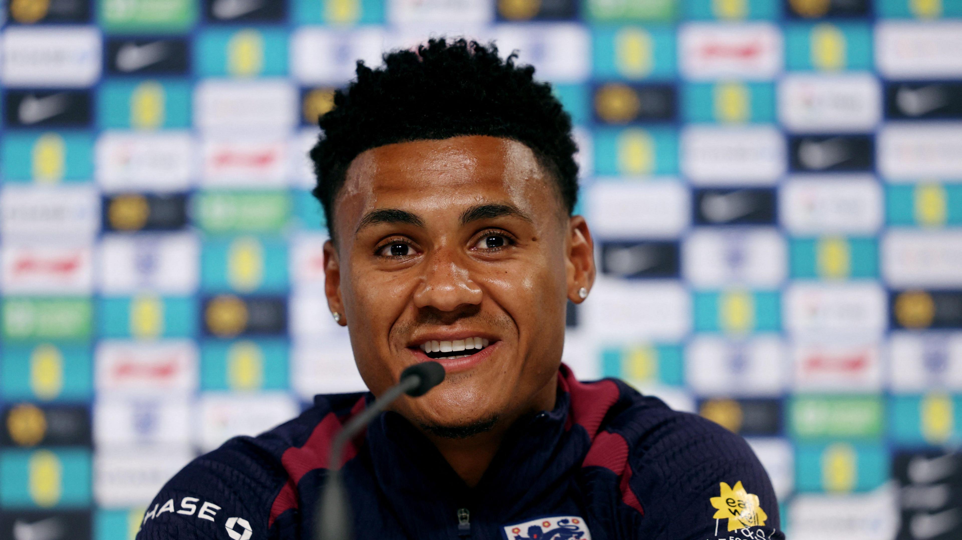 Ollie Watkins speaking into a microphone during a press conference