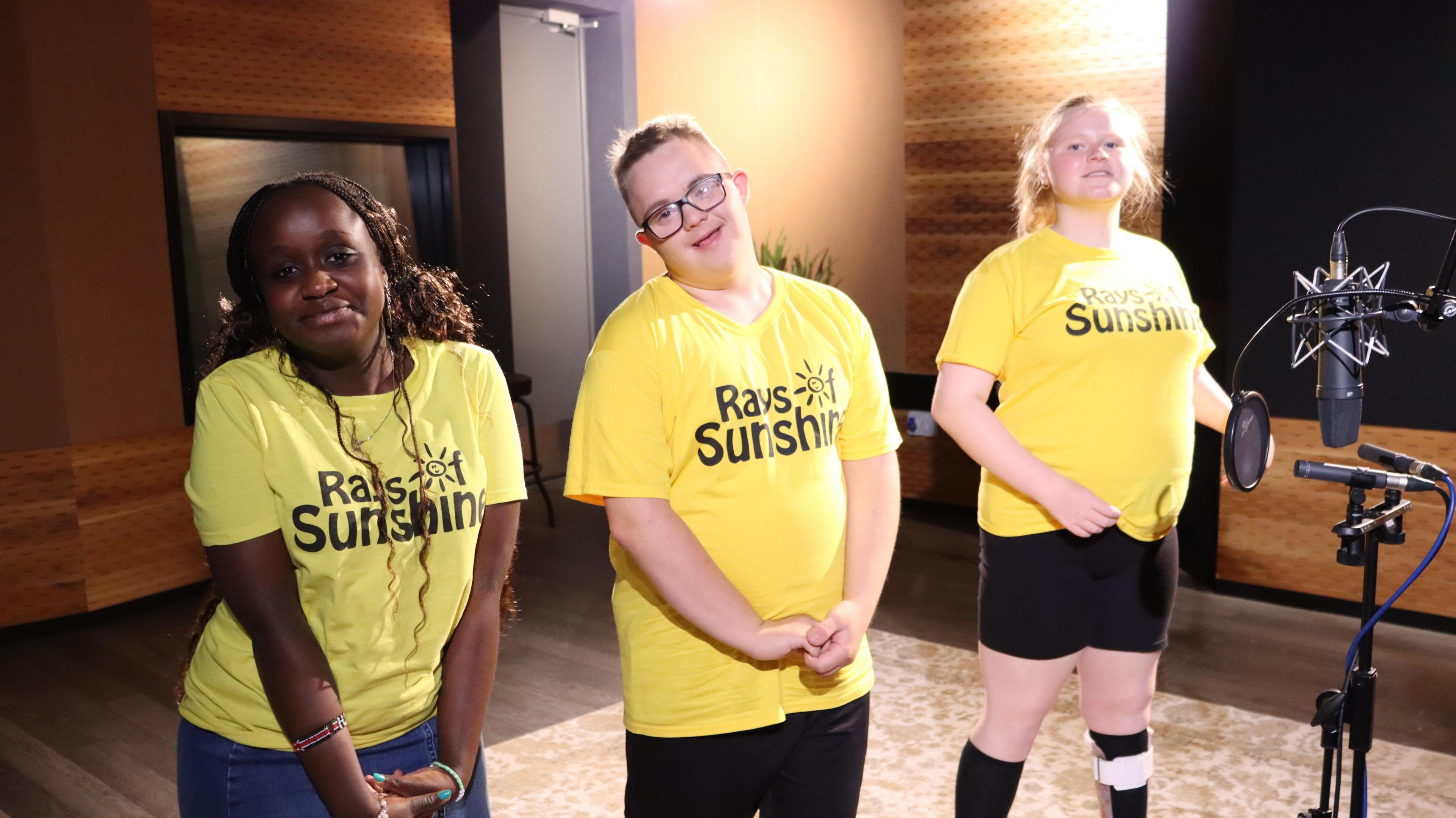 Ruth stood with two other members of the choir. They are in a recording studio and there is a microphone in front of the three of them.