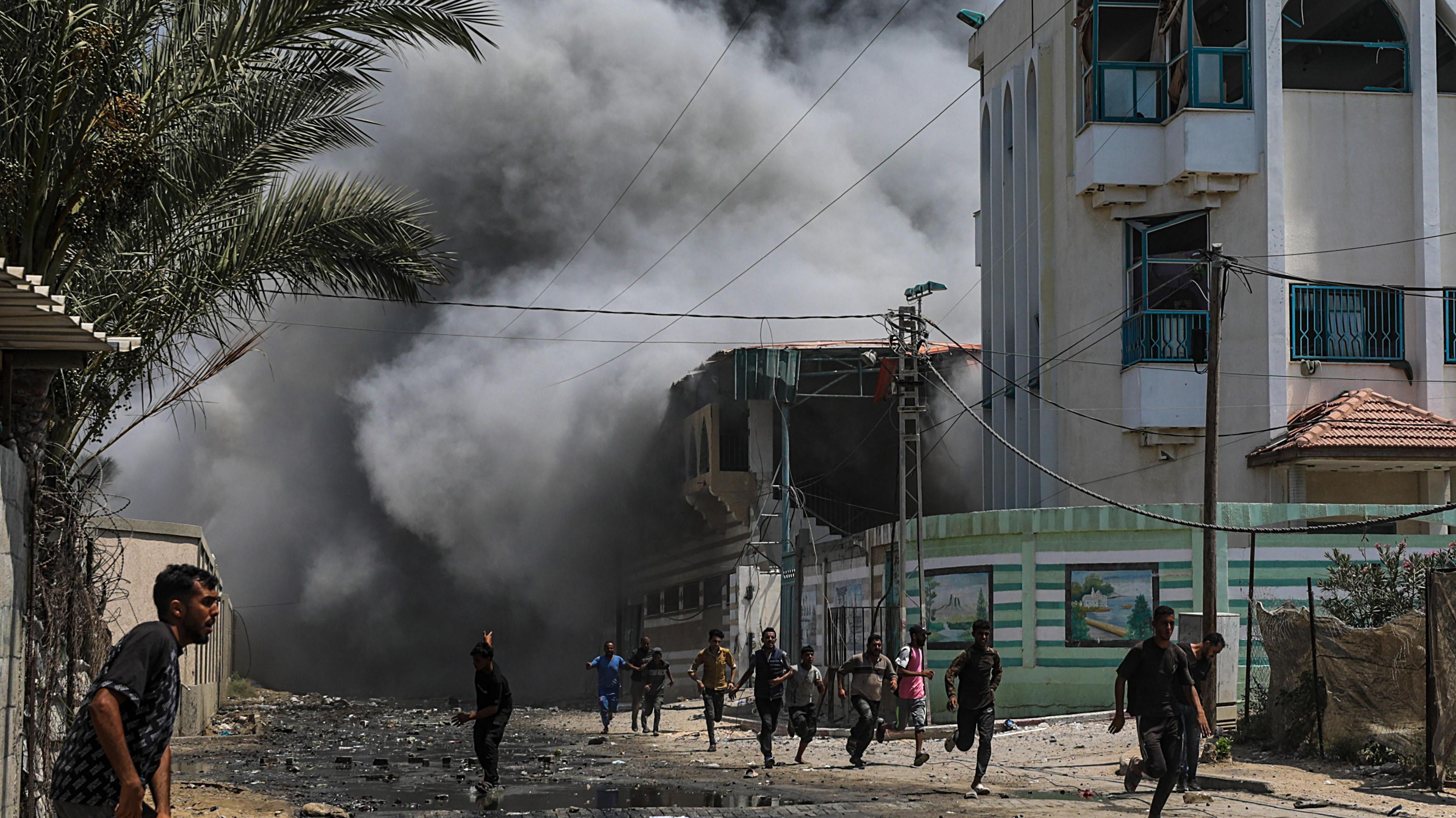 Palestinians run for cover after strike on school