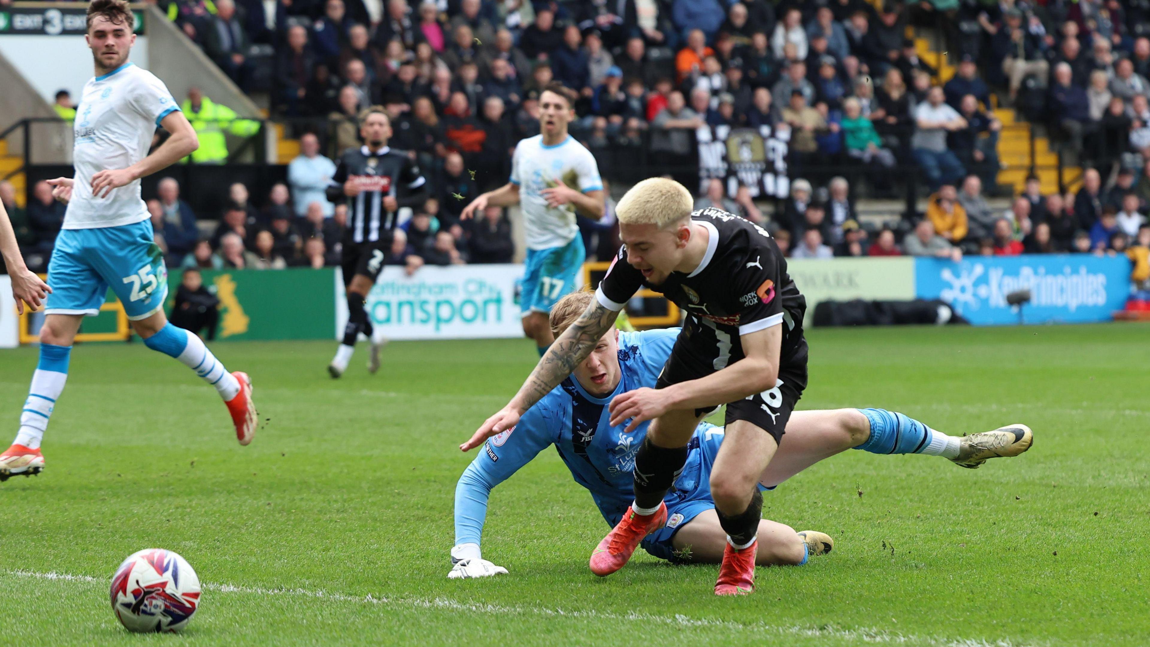 Notts County midfielder Charlie Whitaker dives over Crewe Alexandra goalkeeper Filip Marchall leg during the match between the two sides