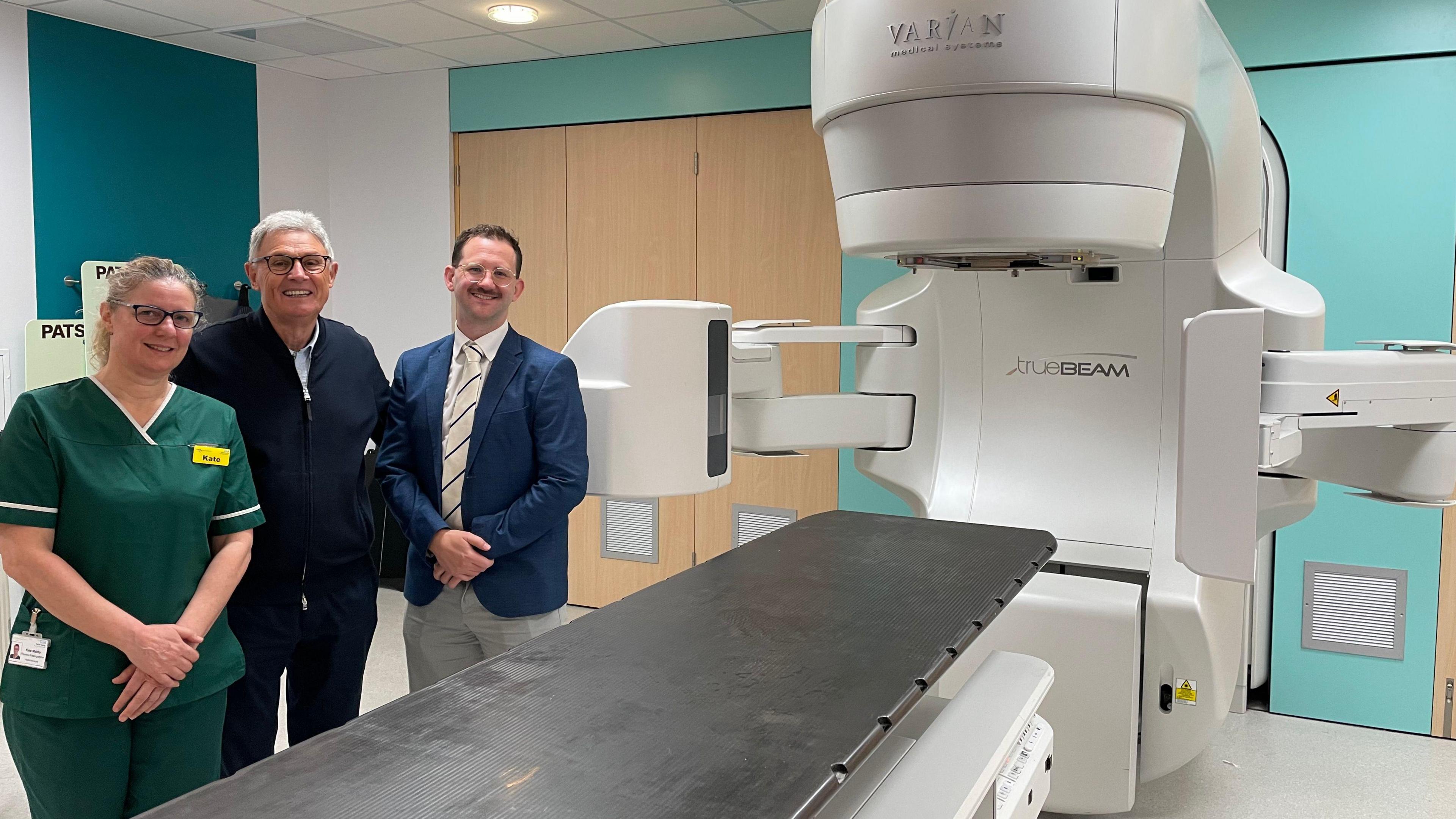 Radiographer Kate Maltby, Michael Robson, Dr Philip Turner stand next to a large medical scanner