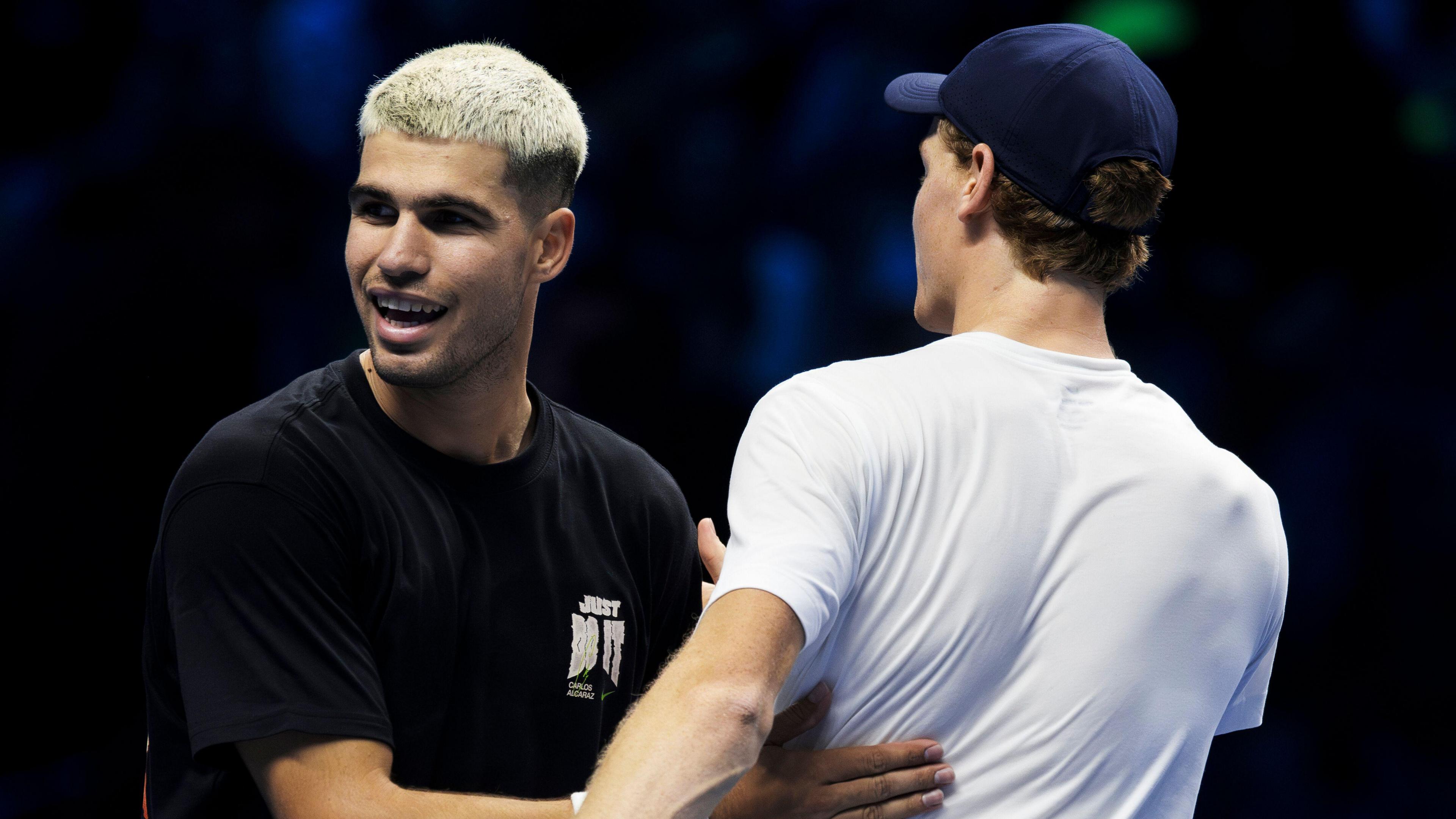 Carlos Alcaraz and Jannik Sinner embrace after their practice session at the 2025 ATP Finals in Turin