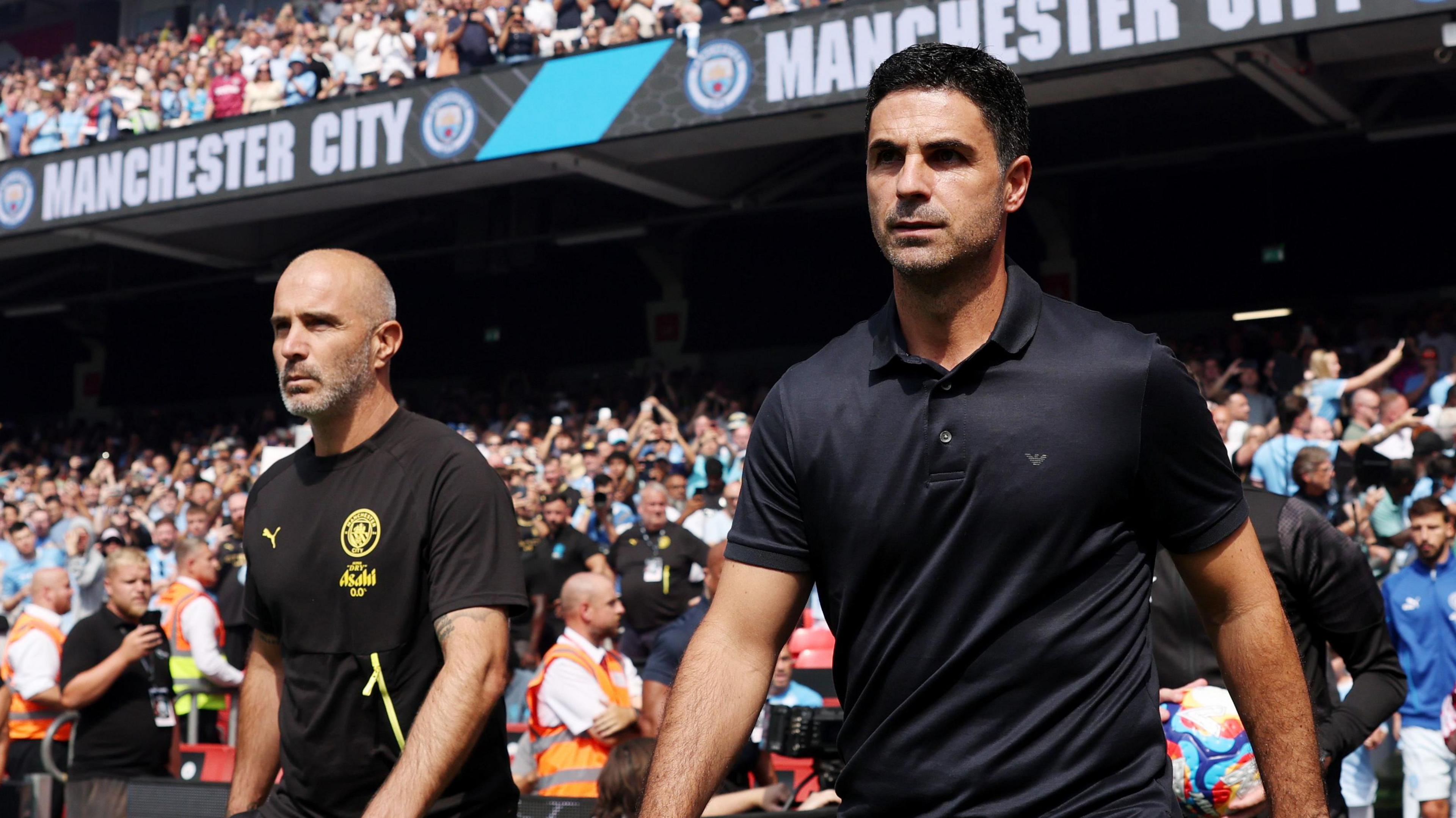 Manchester City manager Enzo Maresca (left) and his Arsenal counterpart Mikel Arteta take to the pitch ahead of the 2026 FA Community Shield.