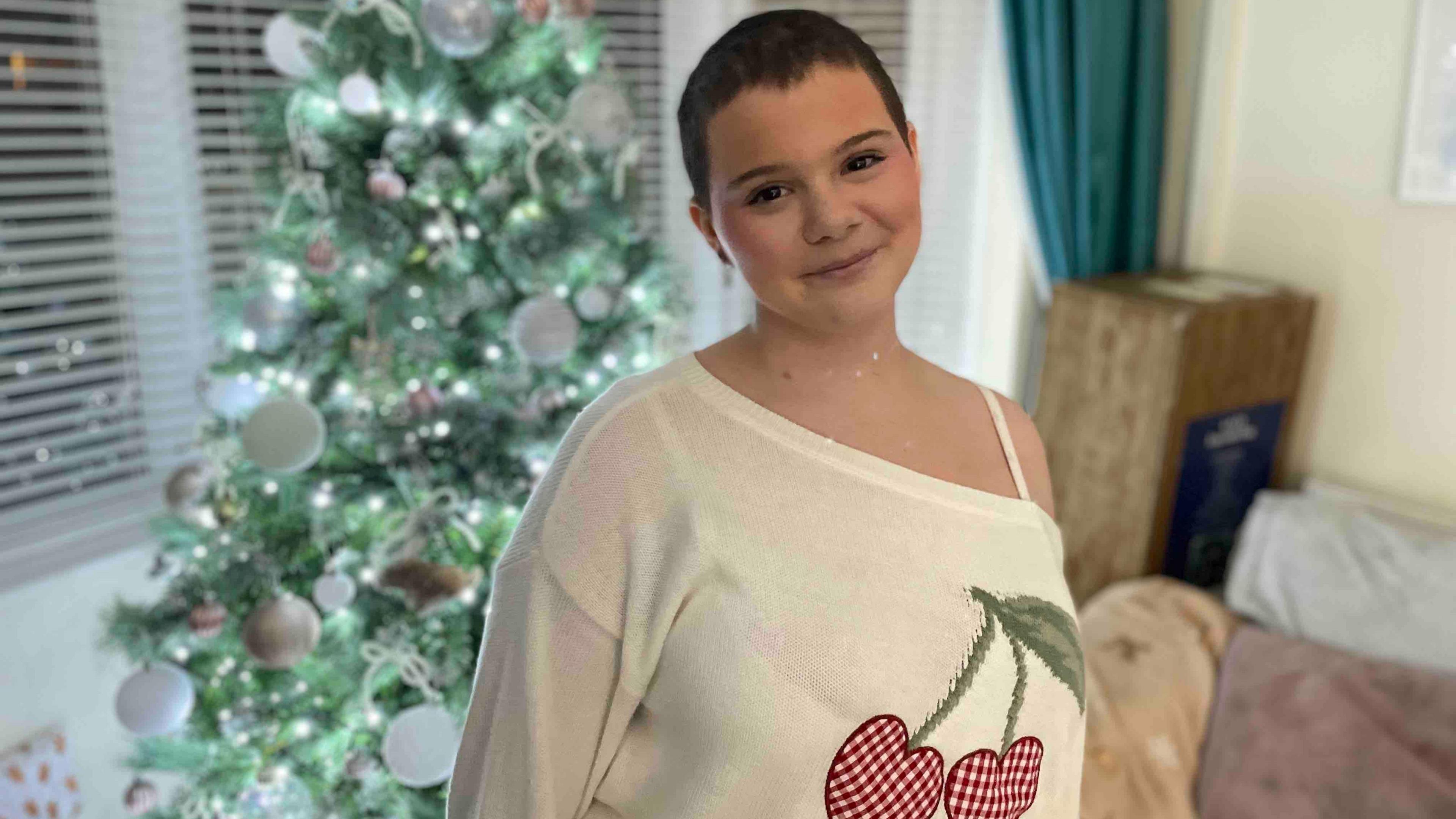 Girl stood in front of Christmas tree