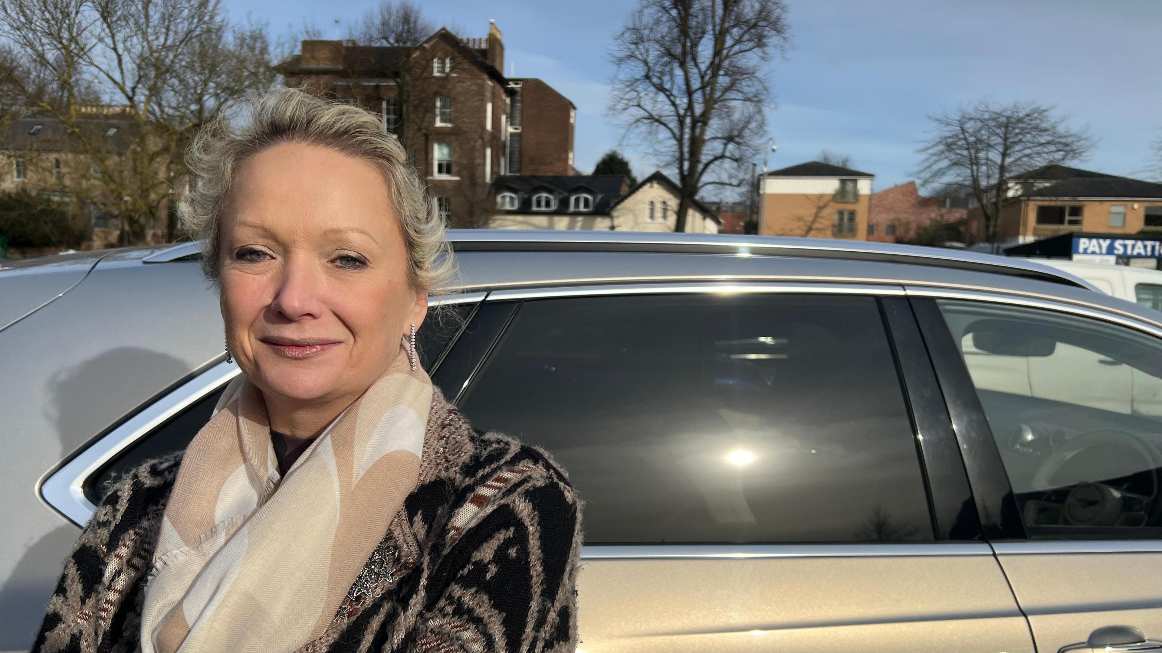 Joanna Sambrook - visiting from Cheshire - is pictured in York's Marygate car park. She is smiling, looking straight at the camera and wearing silver ear-rings and a patterned scarf