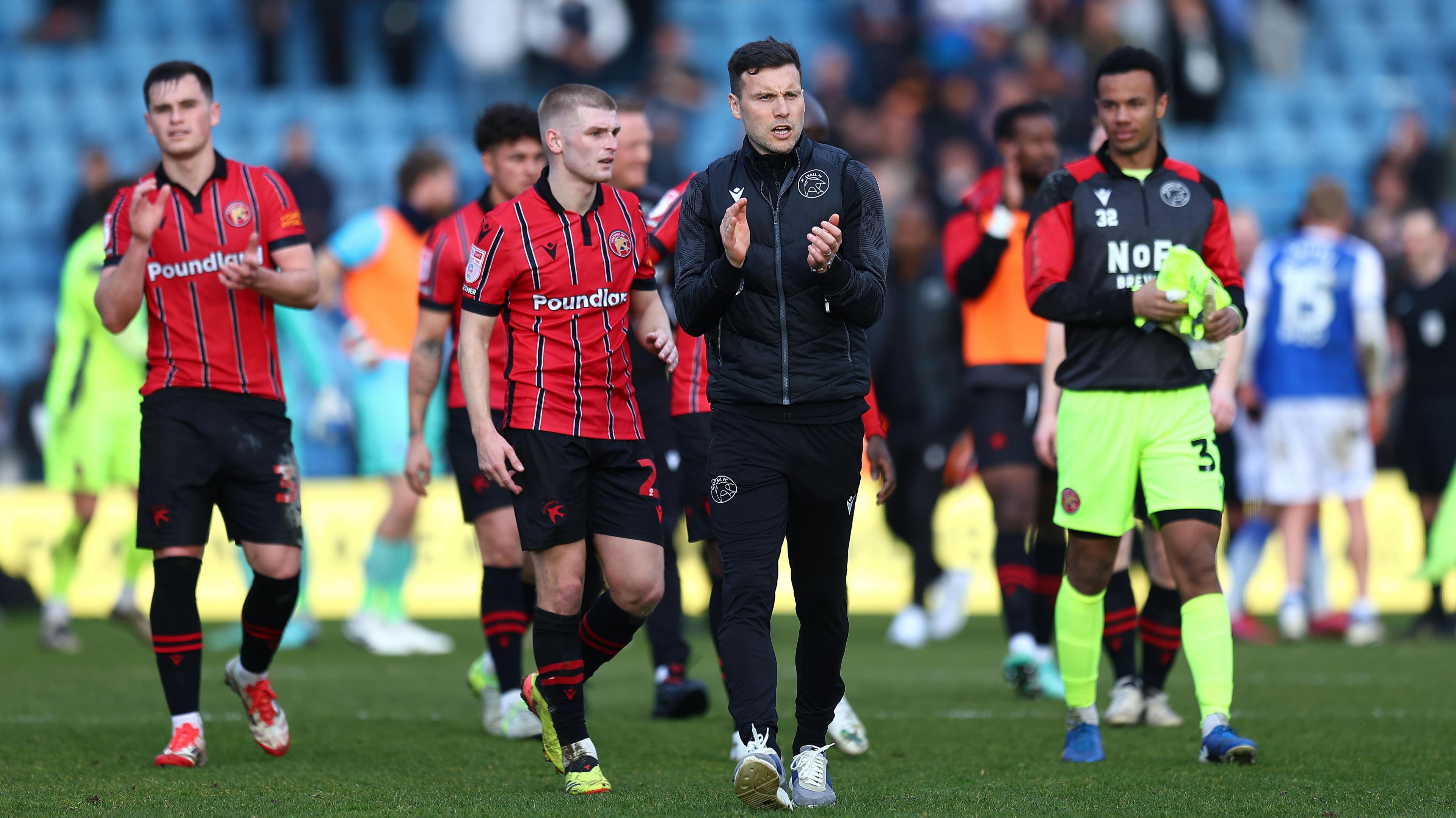 Walsall boss Mat Sadler leads the applause with his squad as they go towards the visiting fans after the 0-0 draw at Gillingham