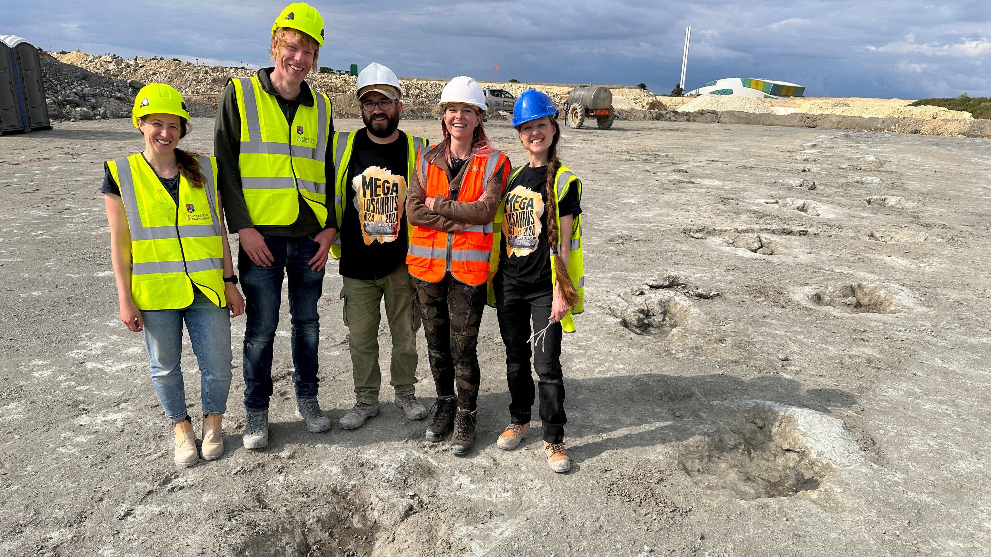 (From left to right) scientists Kirsty Edgar, Richard Butler, Duncan Murdock, Alice Roberts and Emma Nicholls pose next to the footprints found at Dewars Farm Quarry in Oxfordshire.