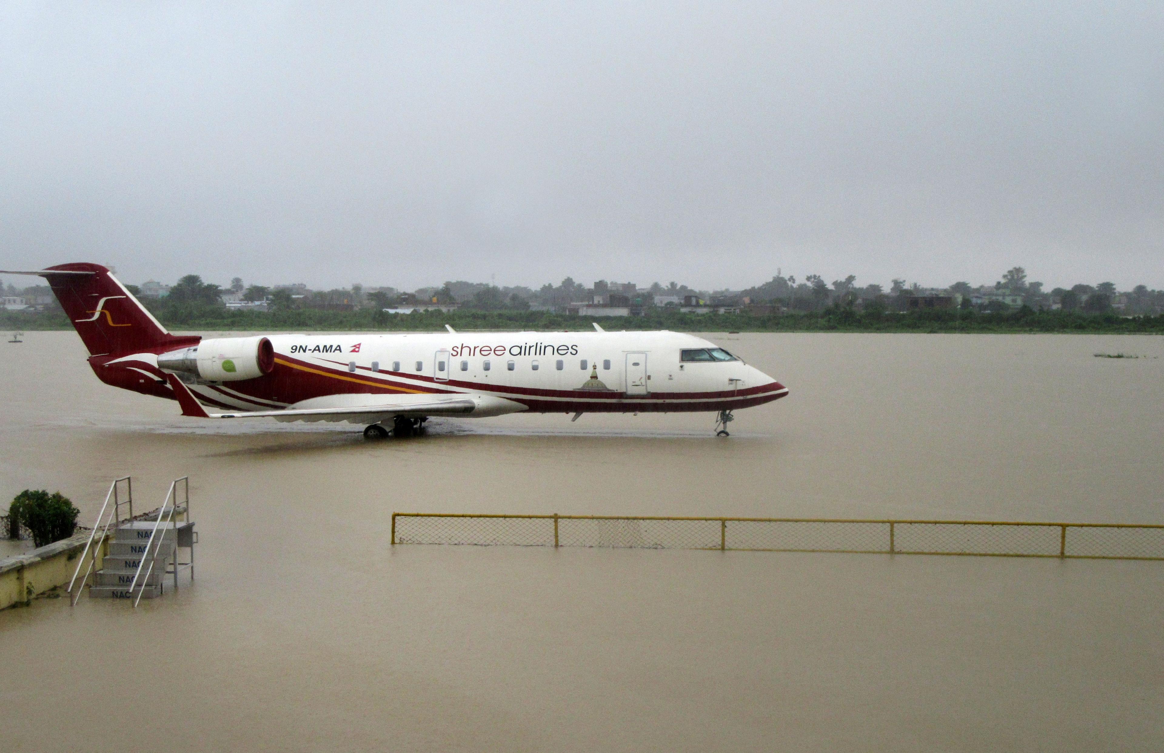 An aircraft is seen parked on the flooded apron of Biratnagar's domestic airport after heavy rains in Biratnagar, some 240km from Nepal's capital Kathmandu, on August 12, 2017.