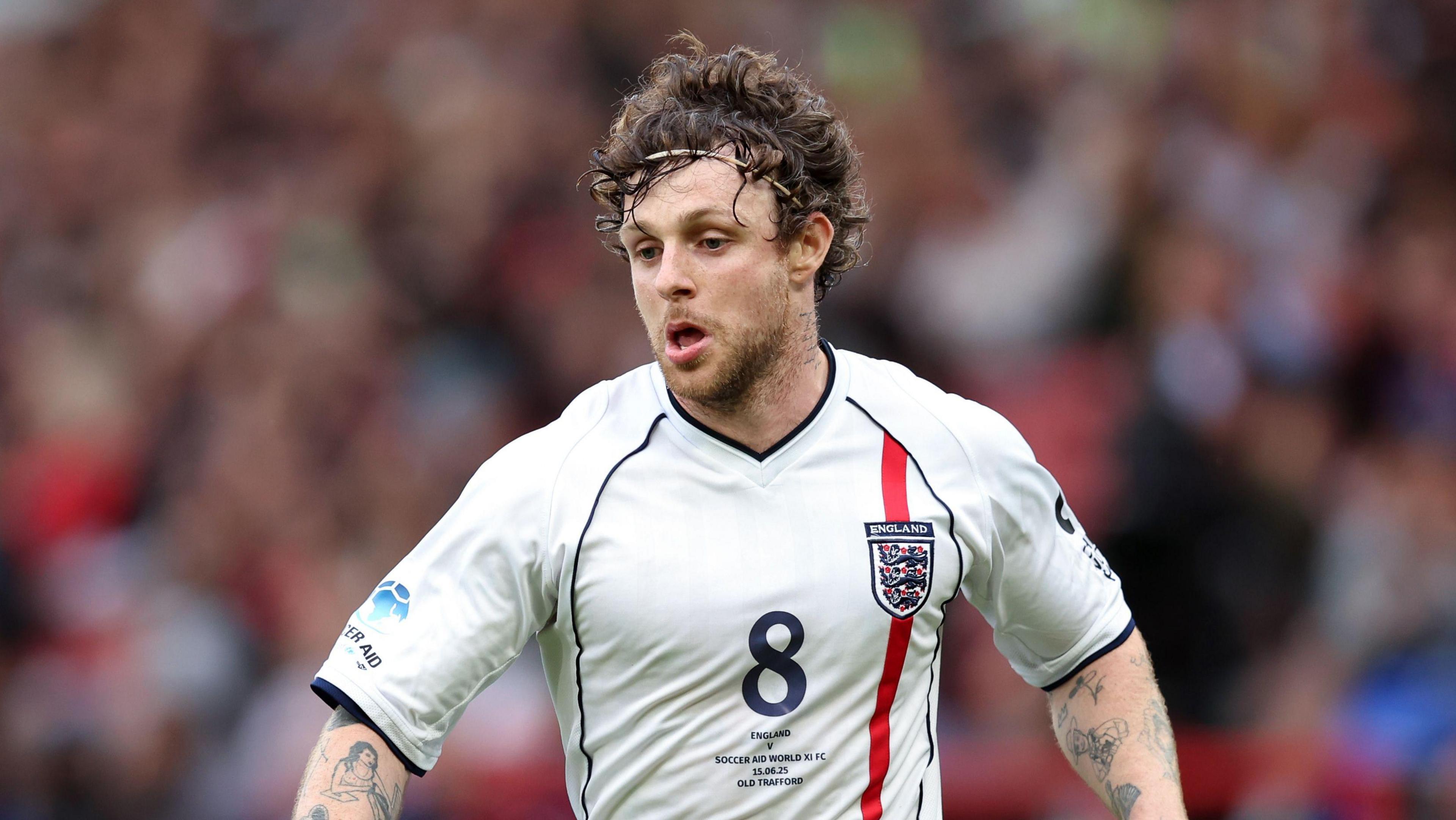 Tom Grennan wearing an England shirt while playing at Soccer Aid 2025