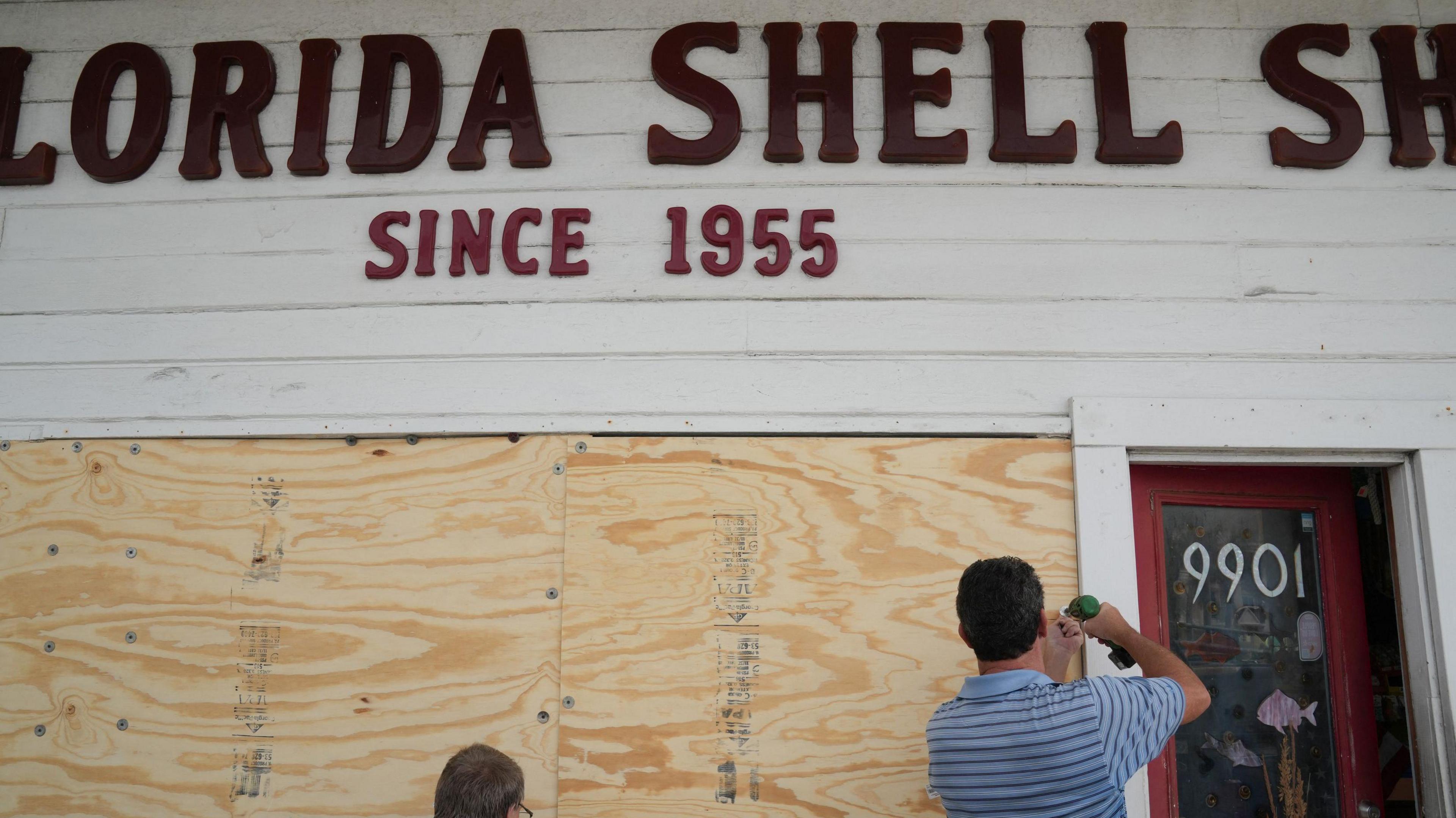 Residents board up a sea shell store ahead of Hurricane Milton's arrival.