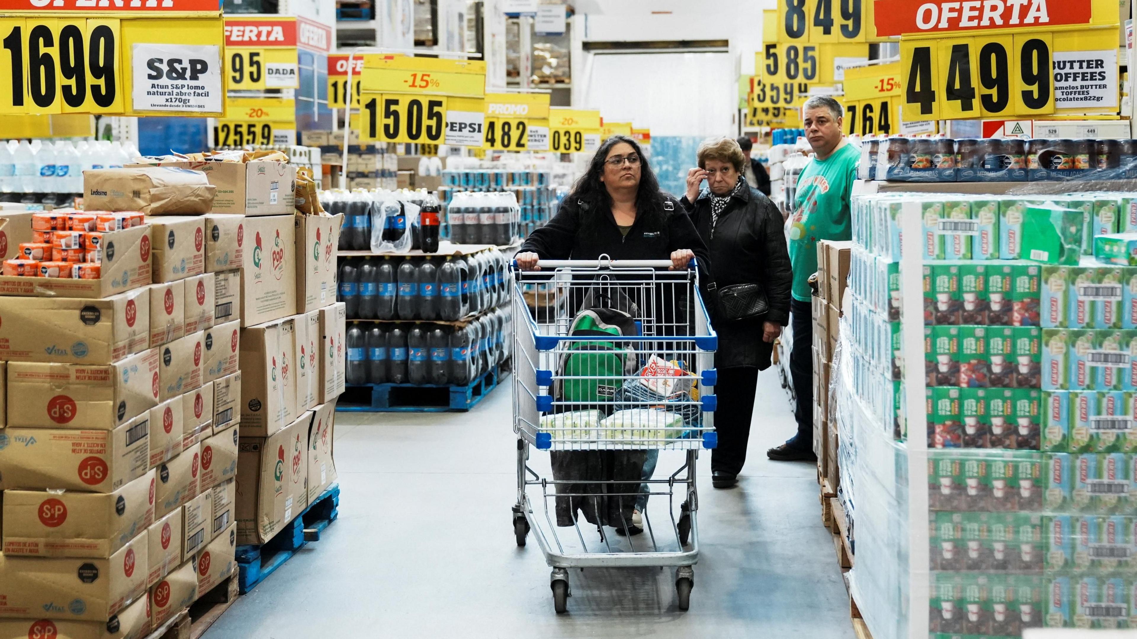 Woman pushes supermarket trolley through a wholesaler's in Buenos Aires, 10 May 2024