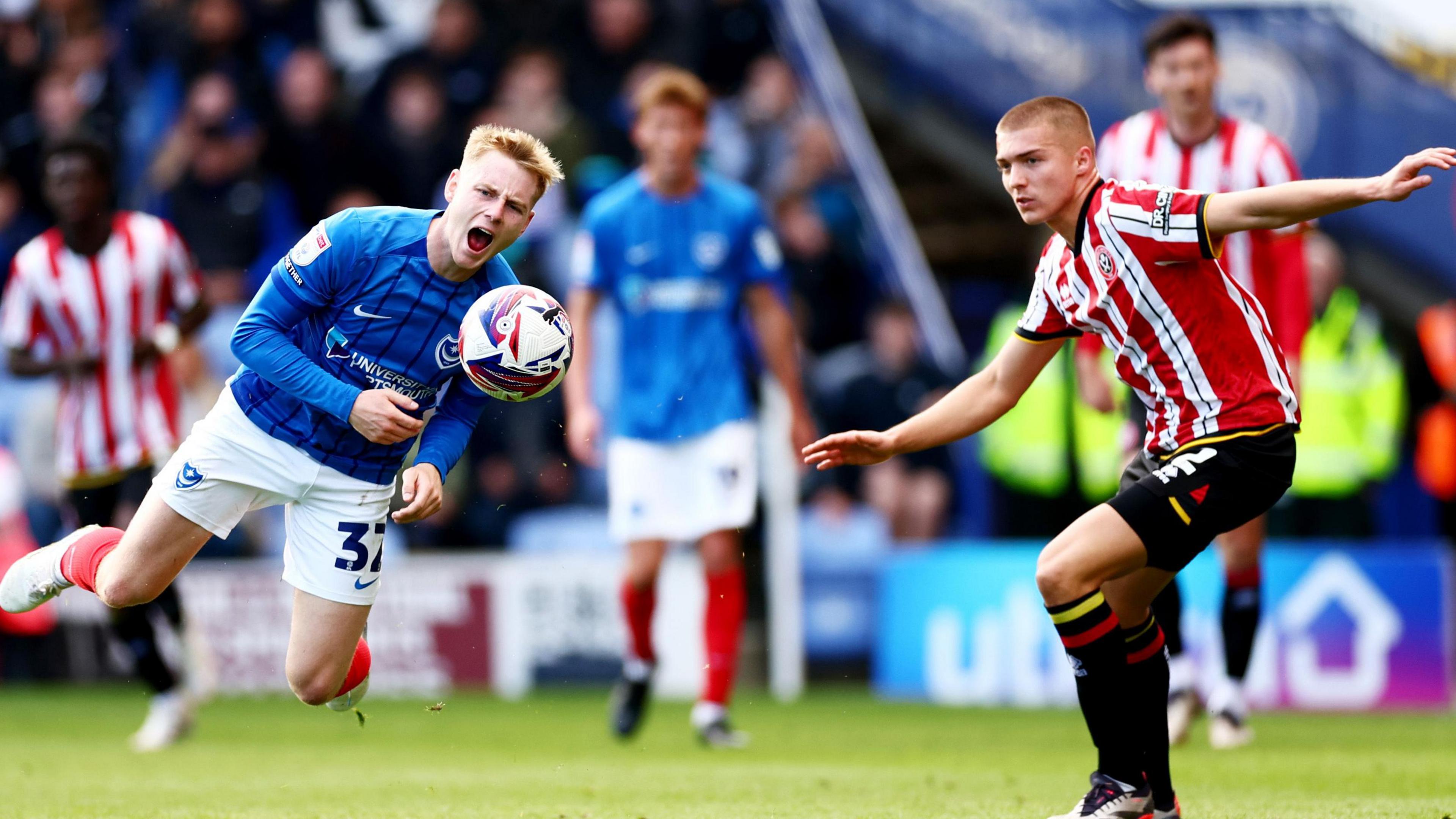 Portsmouth winger Paddy Lane takes a tumble under pressure from Alfie Gilchrist of Sheffield United