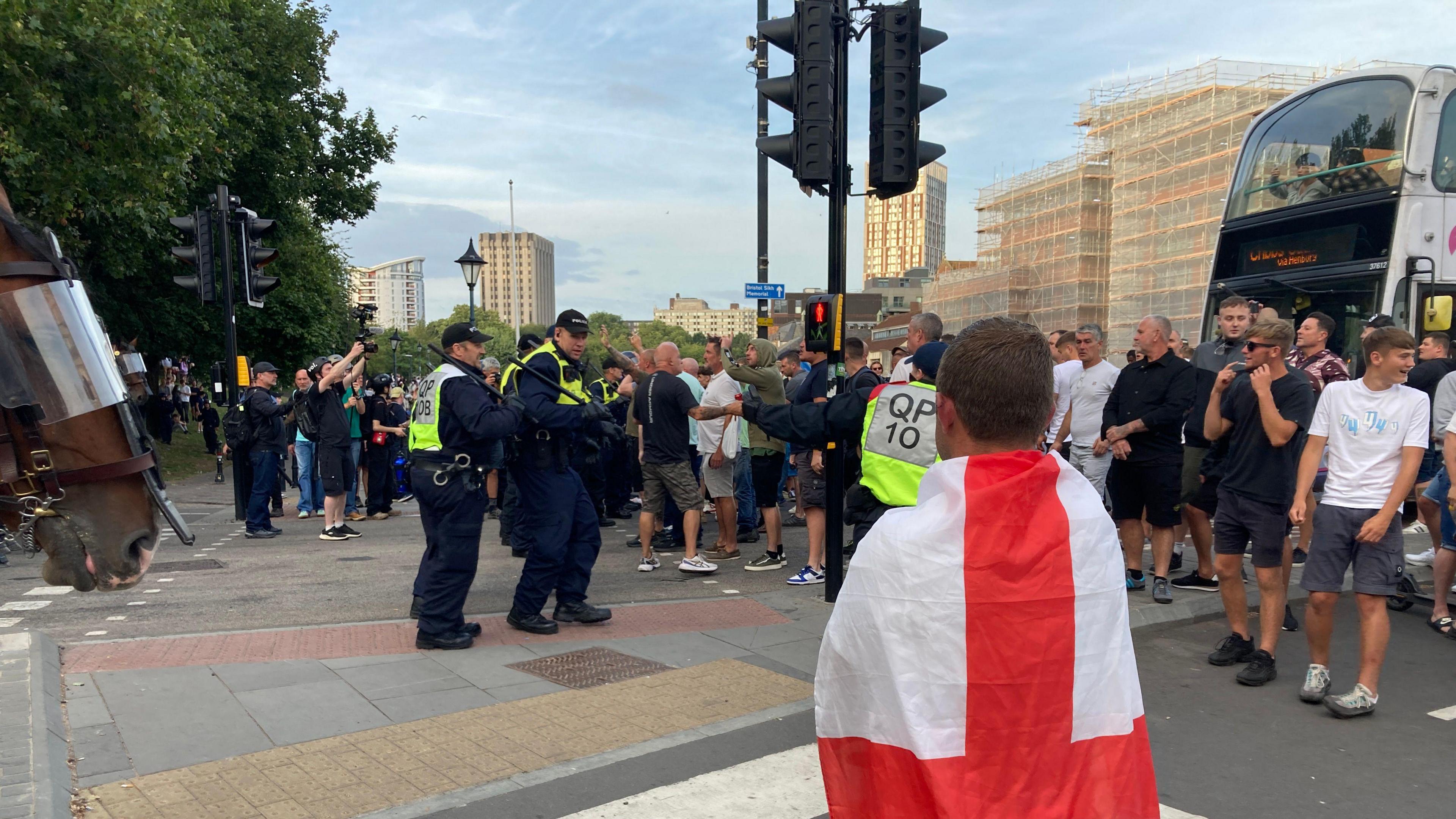 Protest scene in Bristol. A large crowd can be seen, along with police. 