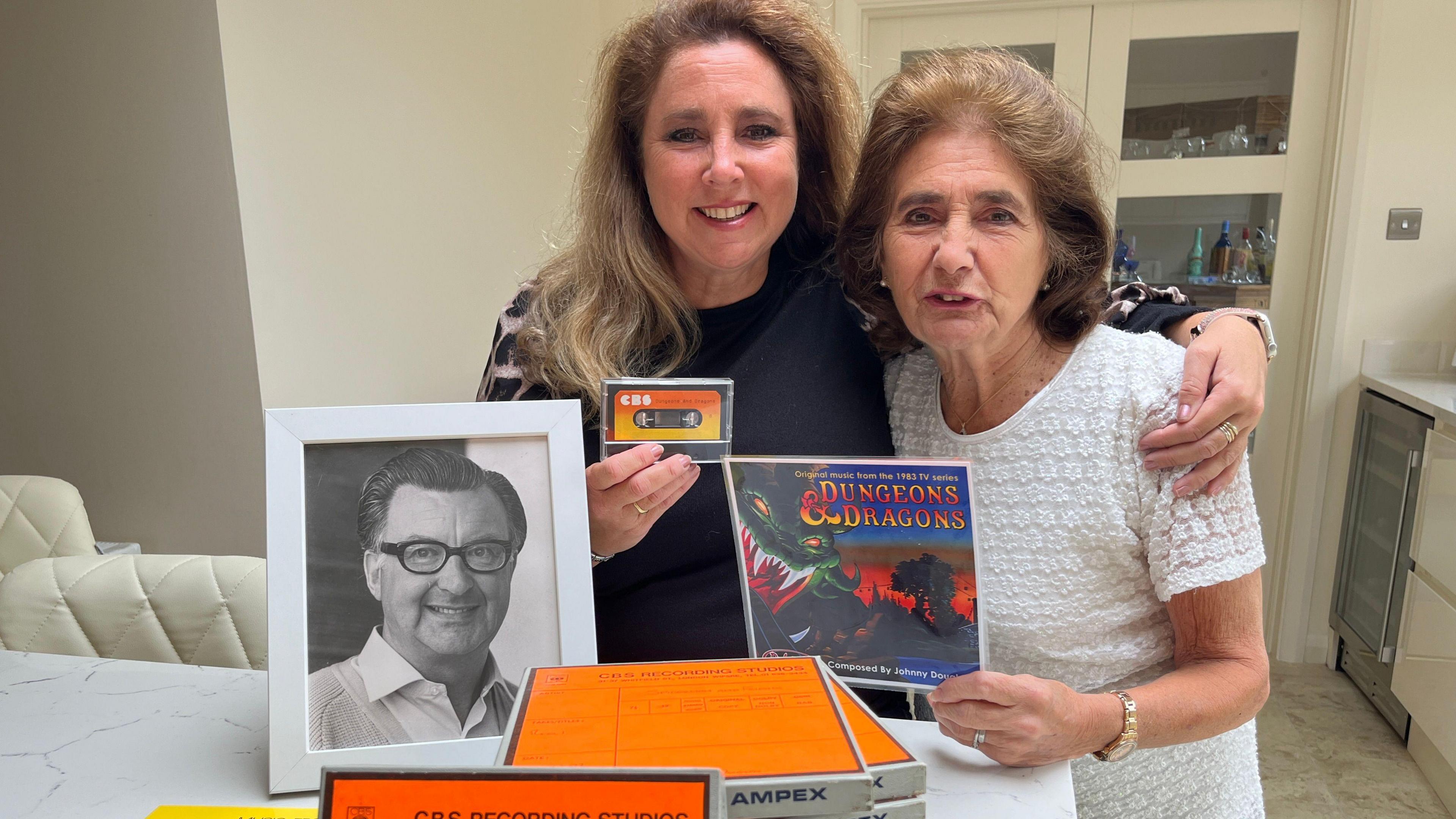 Ms Camby and her mum Norma, with Dungeons and Dragons memorabilia and a photo of Mr Douglas