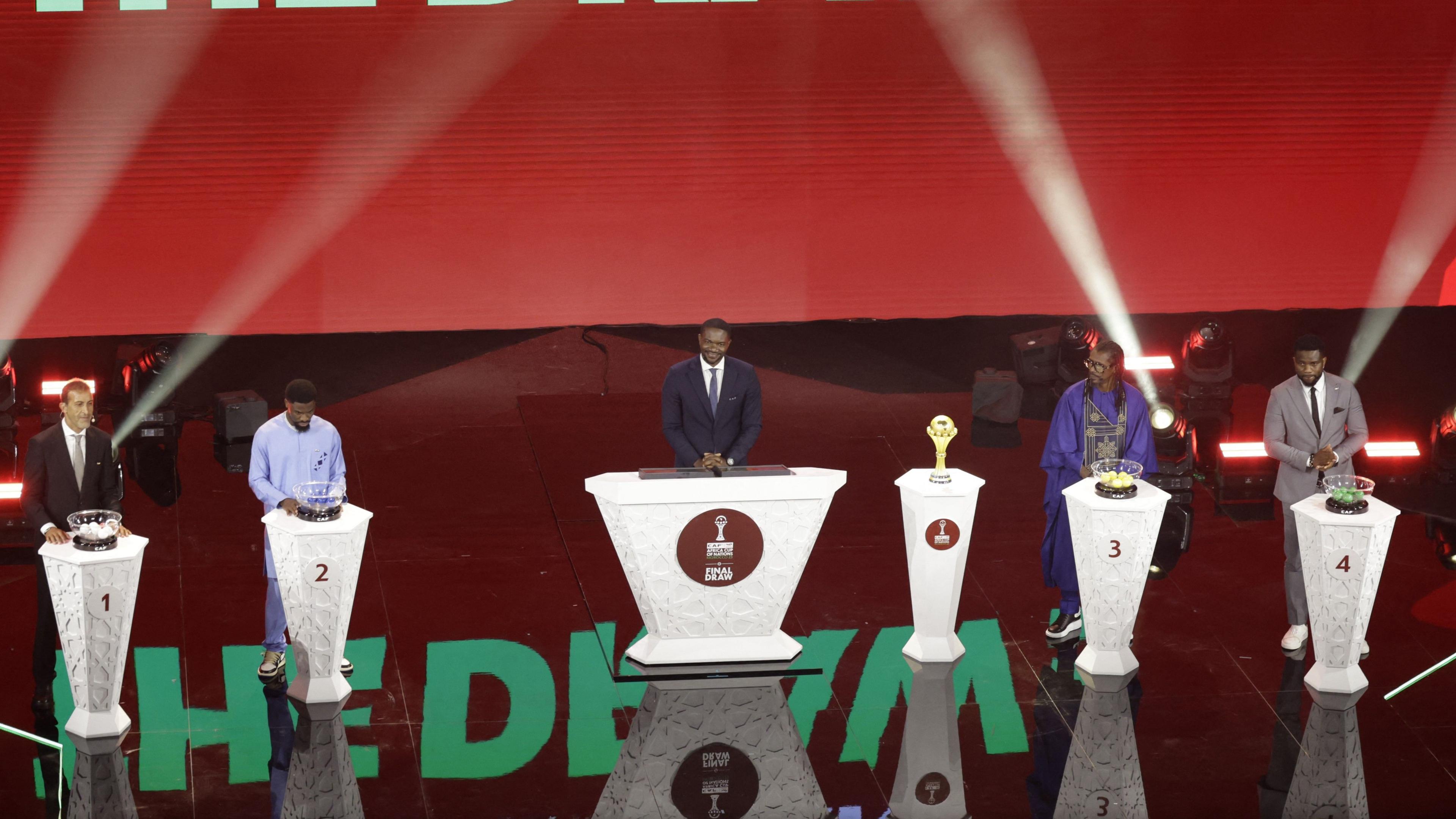 (From L to R) Mustapha Hadji, Serge Aurier, Caf's Samson Adamu, Aliou Cisse and Joseph Yobo stand on stage during the draw for Afcon 2025